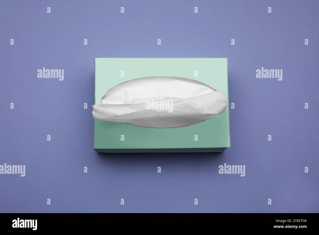 Scatola di fazzoletti di carta su sfondo viola, vista dall'alto Foto Stock