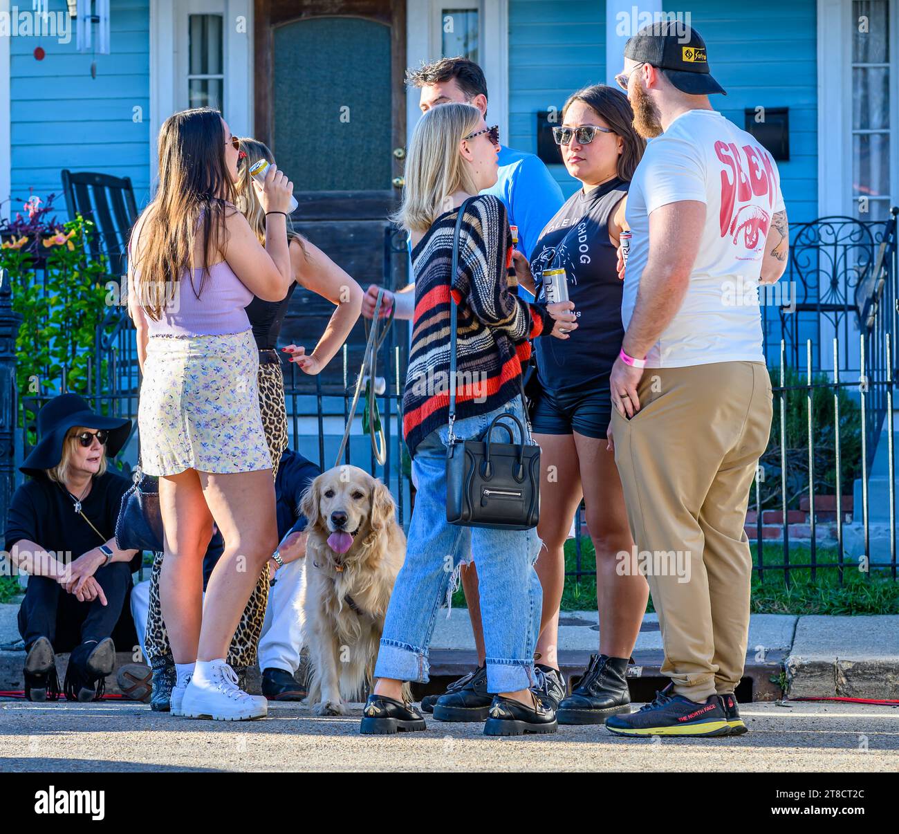 NEW ORLEANS, LOS ANGELES, USA - 19 NOVEMBRE 2023: Friends and Their Golden Retriever socialize on Leonidas Street Between musical acts during Poboy Festival Foto Stock