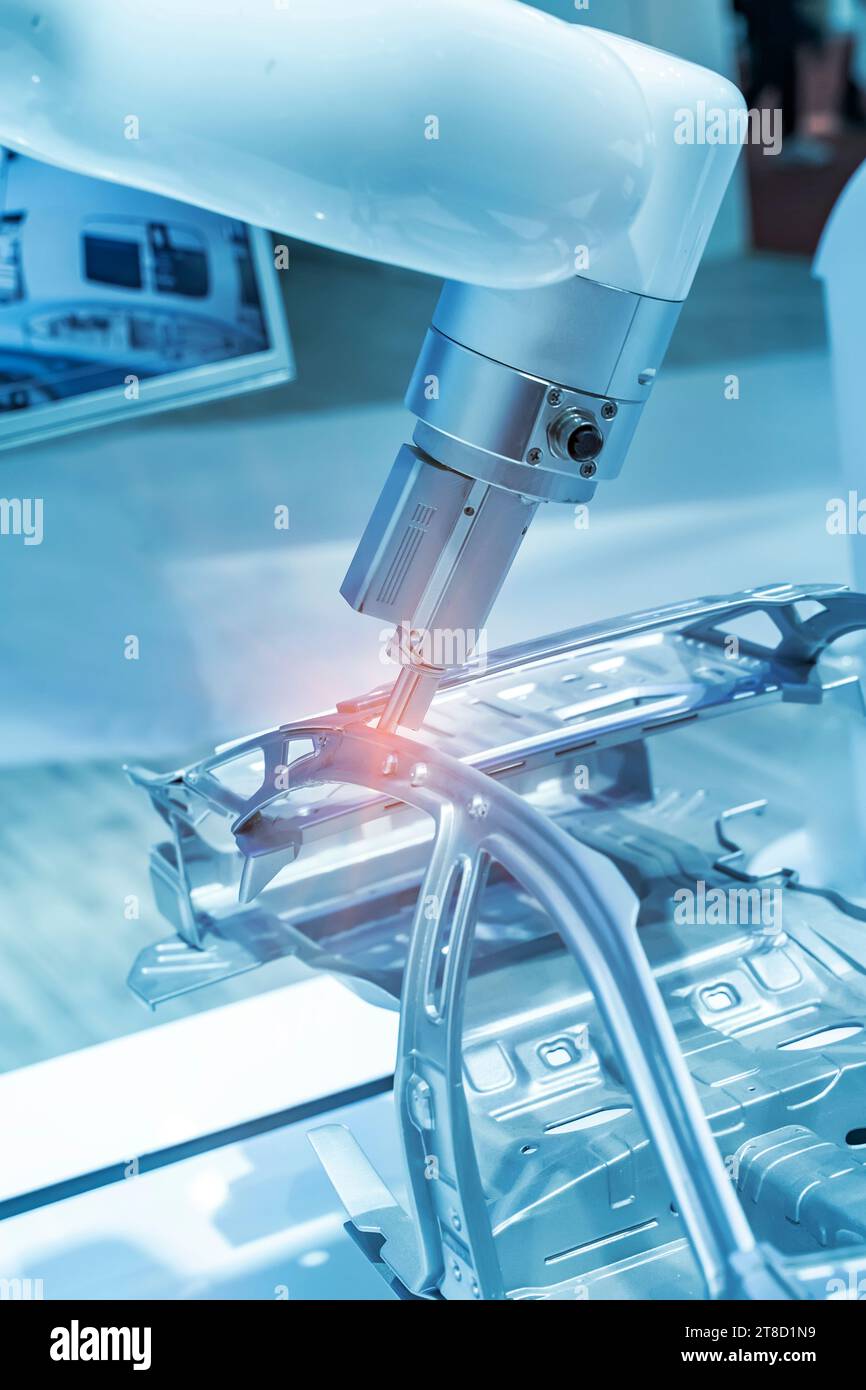 I bracci di saldatura robotizzati saldano il componente della vettura in fabbrica in fase di produzione della linea di assemblaggio Foto Stock