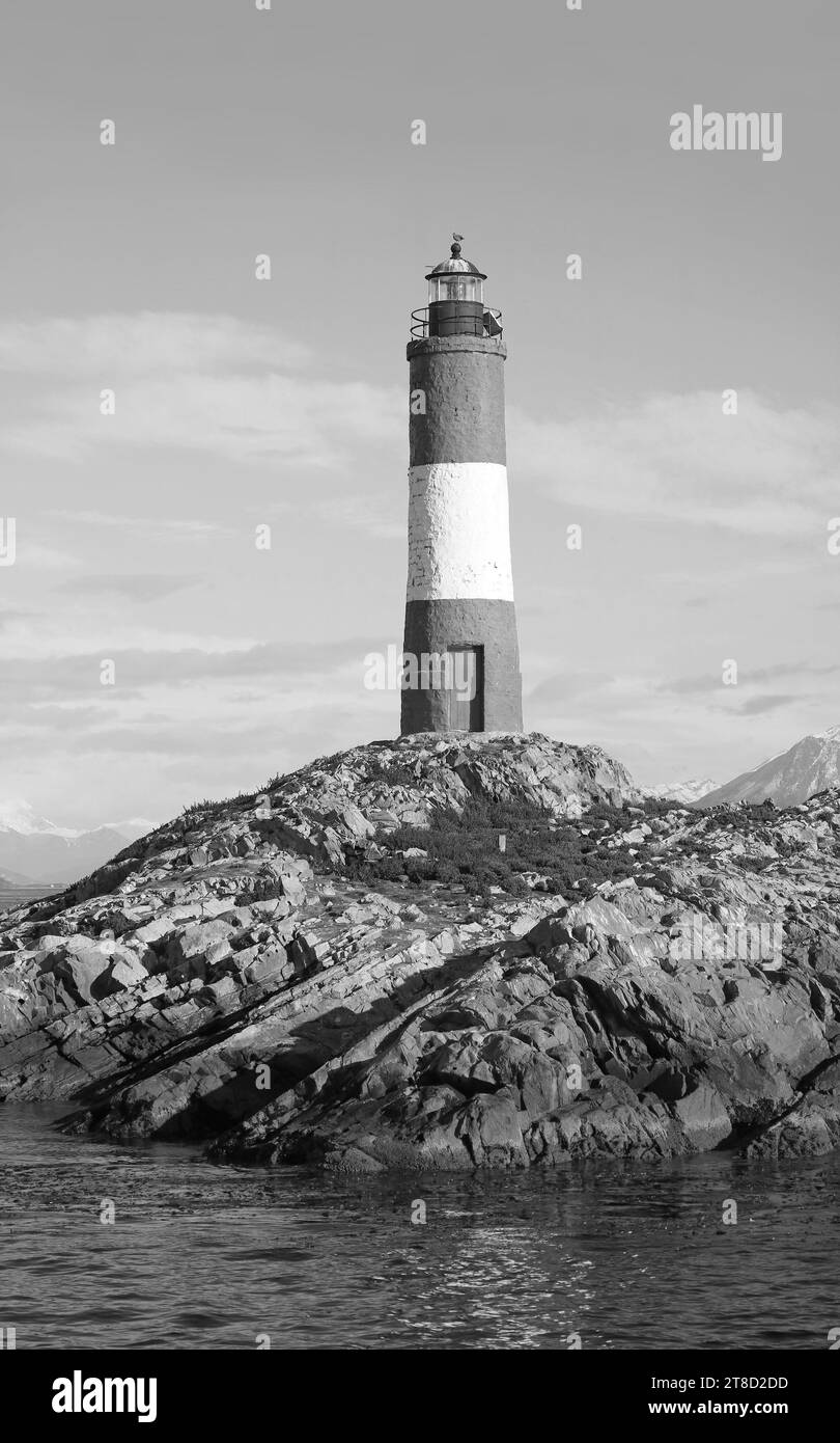 Faro di Les Eclaireurs su isole rocciose, simbolo del canale di Beagle, Ushuaia, Terra del fuoco, Argentina, Sud America in monocromo Foto Stock