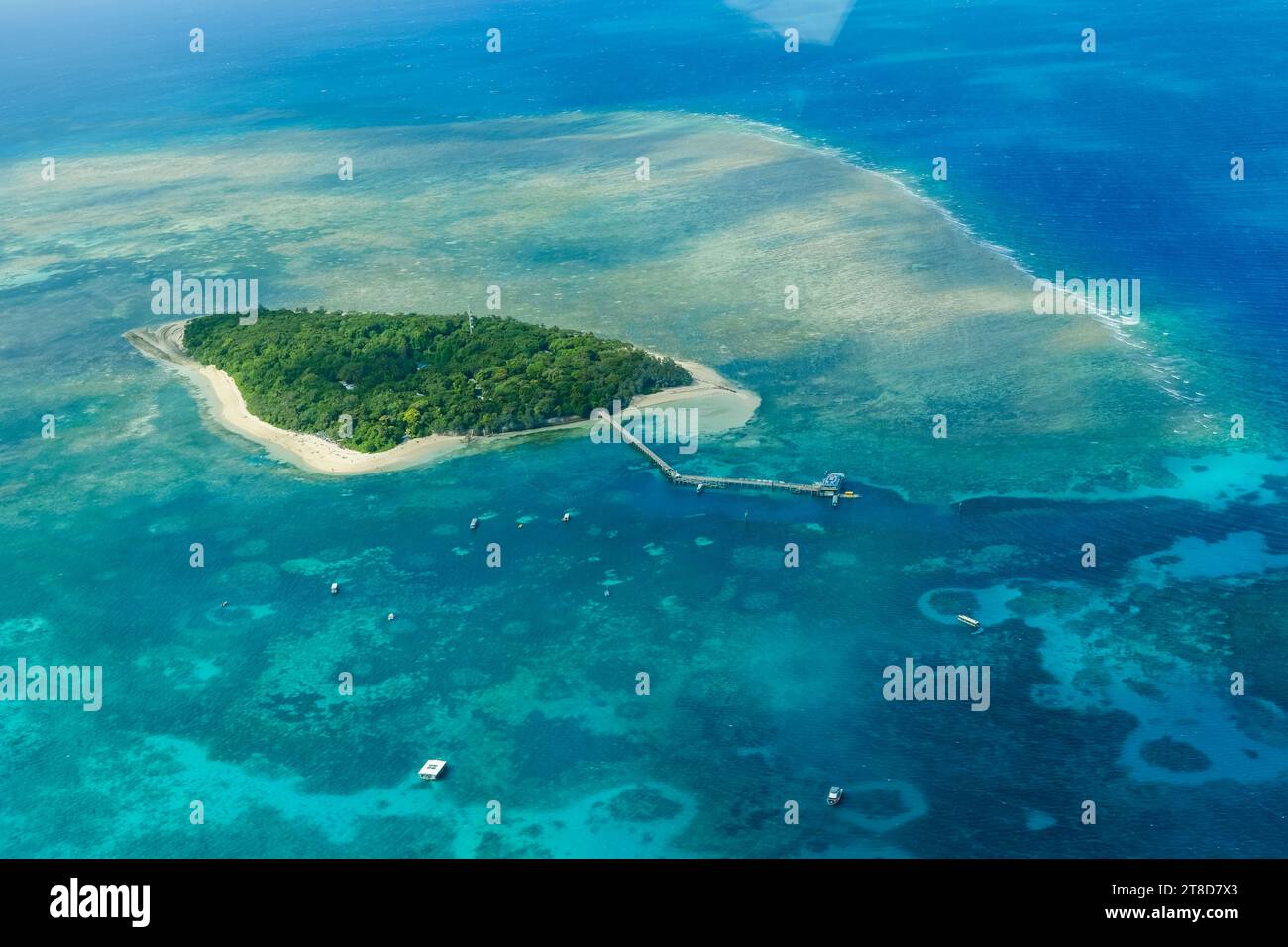 Una vista aerea delle barriere coralline e delle limpide acque turchesi che circondano Green Island, una piccola isola tropicale nella grande Barriera Corallina esterna Foto Stock