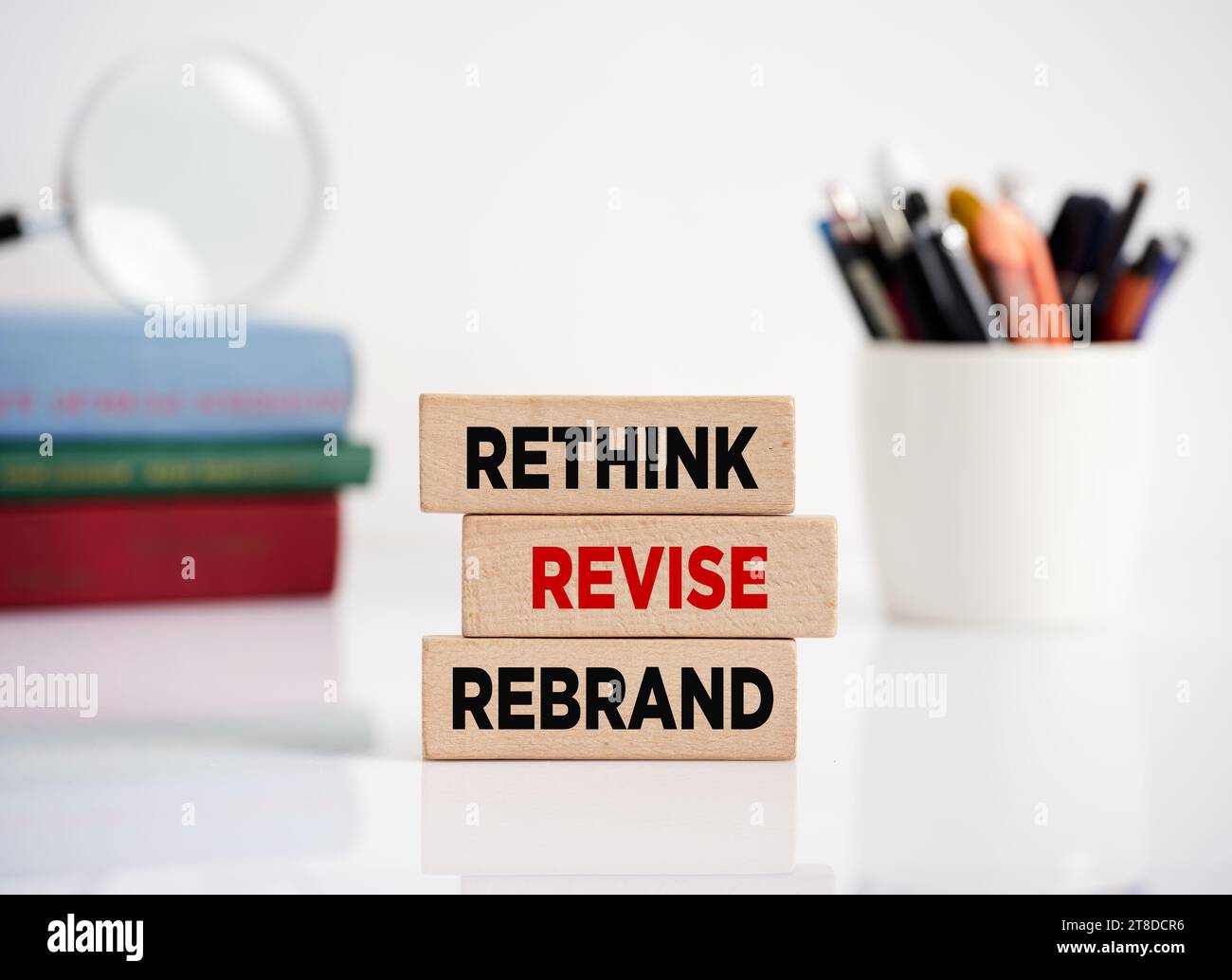 Branding o brand building nella gestione aziendale e nel marketing. Il messaggio ripensa, rivede e ridisegna i blocchi di legno su una scrivania dell'ufficio. Foto Stock