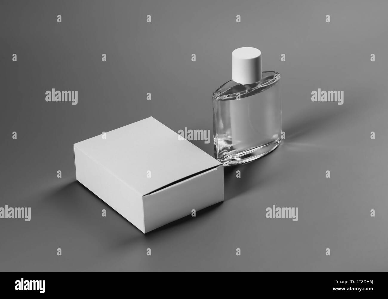 Modello di una scatola bianca chiusa e una bottiglia di profumo trasparente, etichetta per design, branding, stampa. Modello di confezione per fragranze di alta qualità. Prodotto Foto Stock