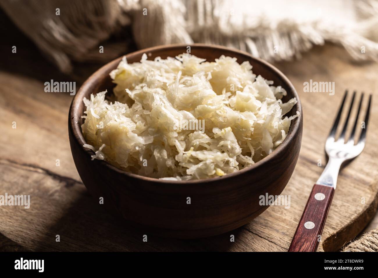 Cavolo fermentato in una ciotola su tagliere di legno. Foto Stock