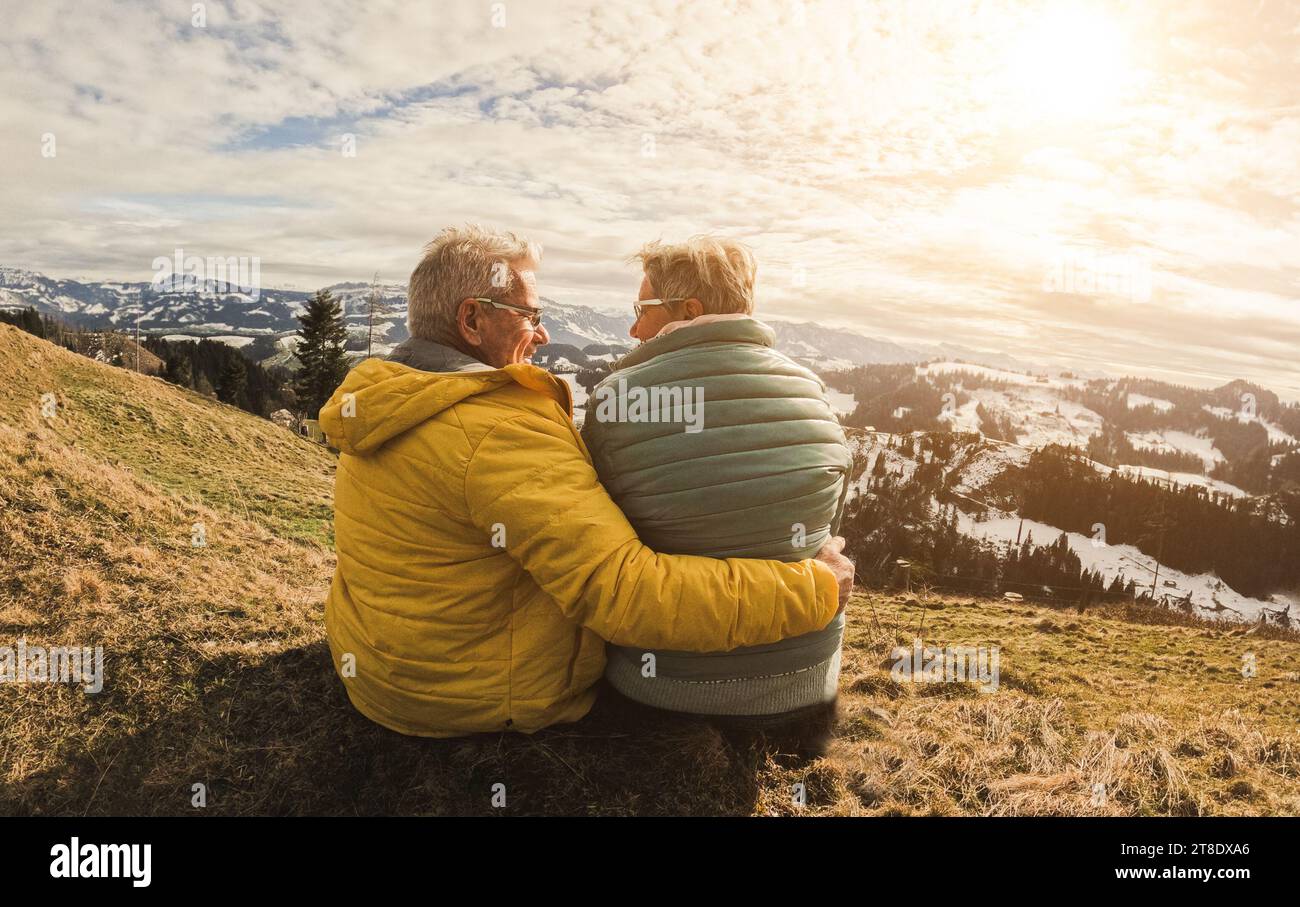 Felice coppia anziana che ha un momento tenero durante una giornata di escursioni in montagna - Winter and Love Concept - Soft focus sul viso della donna Foto Stock