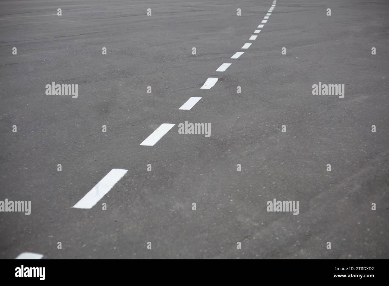 Pista ciclabile. Segni sulla strada. Linea bianca rotta sull'asfalto. Foto Stock