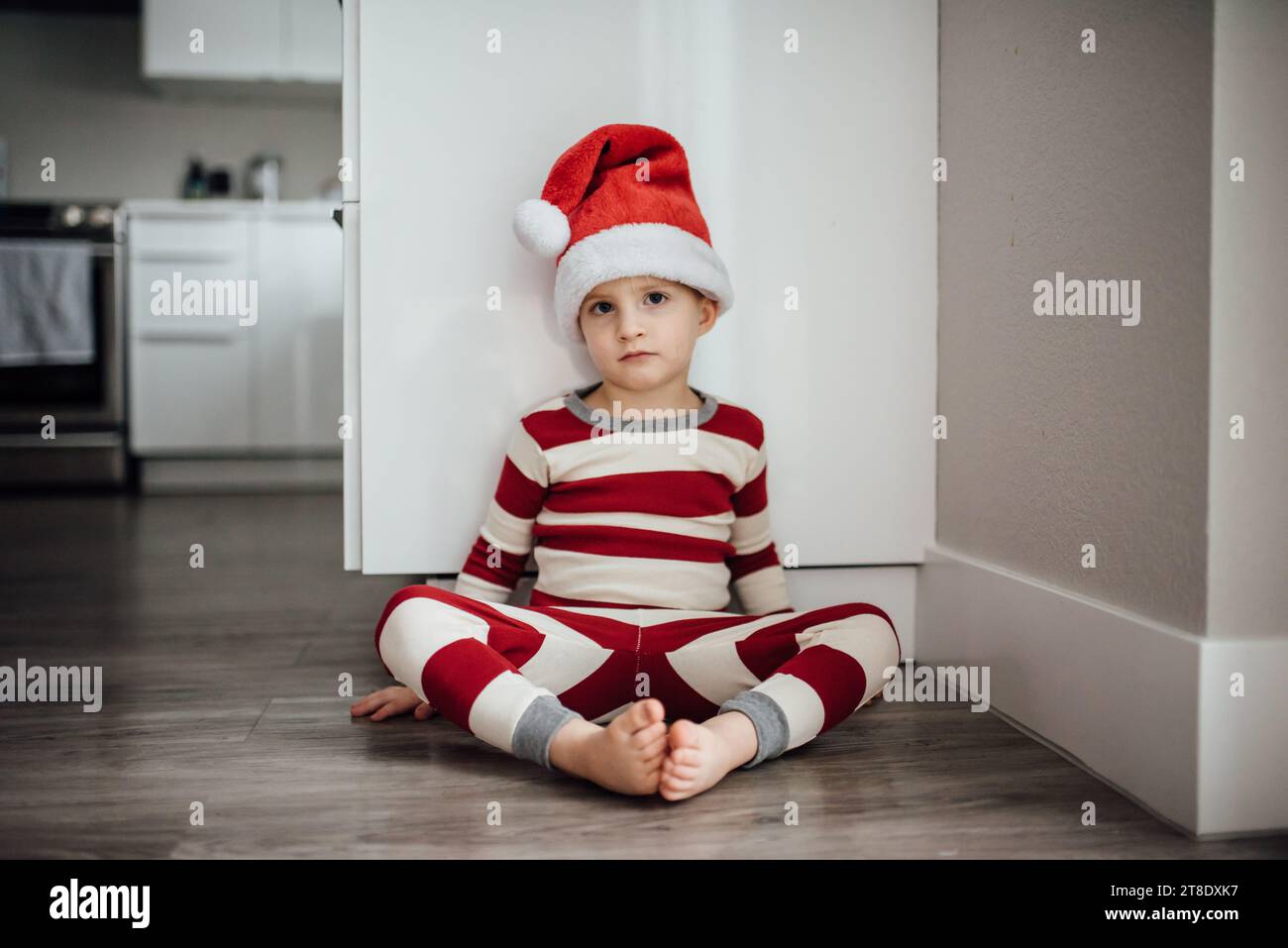 Un bambino guarda seriamente la fotocamera mentre indossa il christmas paj Foto Stock