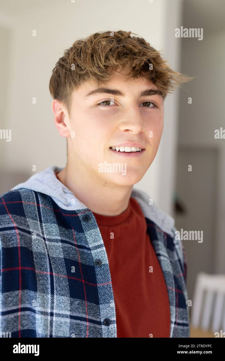 Ritratto di un adolescente maschio caucasico felice con i capelli biondi corti a casa Foto Stock