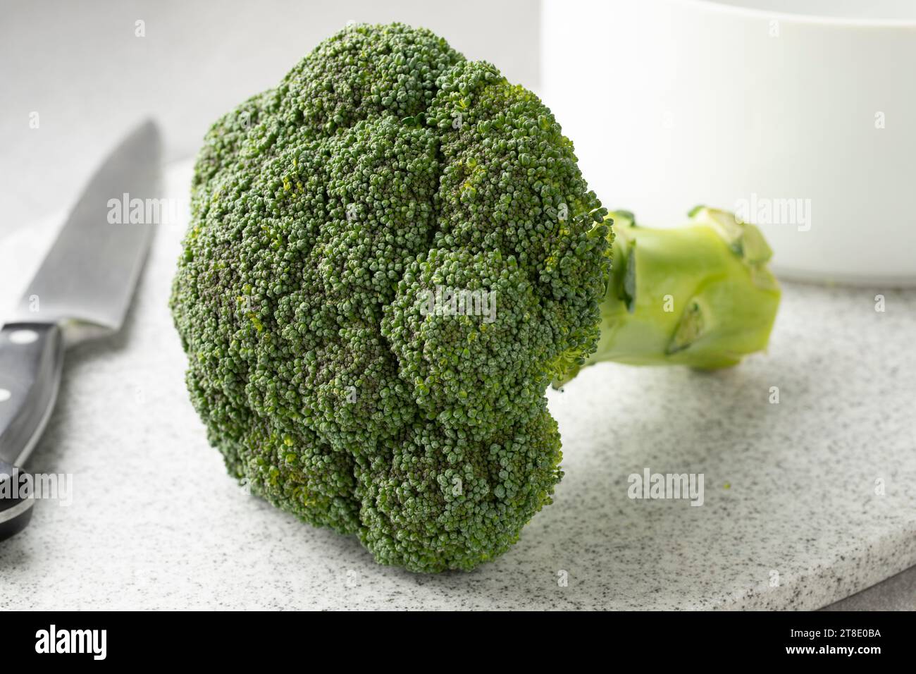 Broccoli crudi verdi freschi e sani su un tagliere da vicino Foto Stock