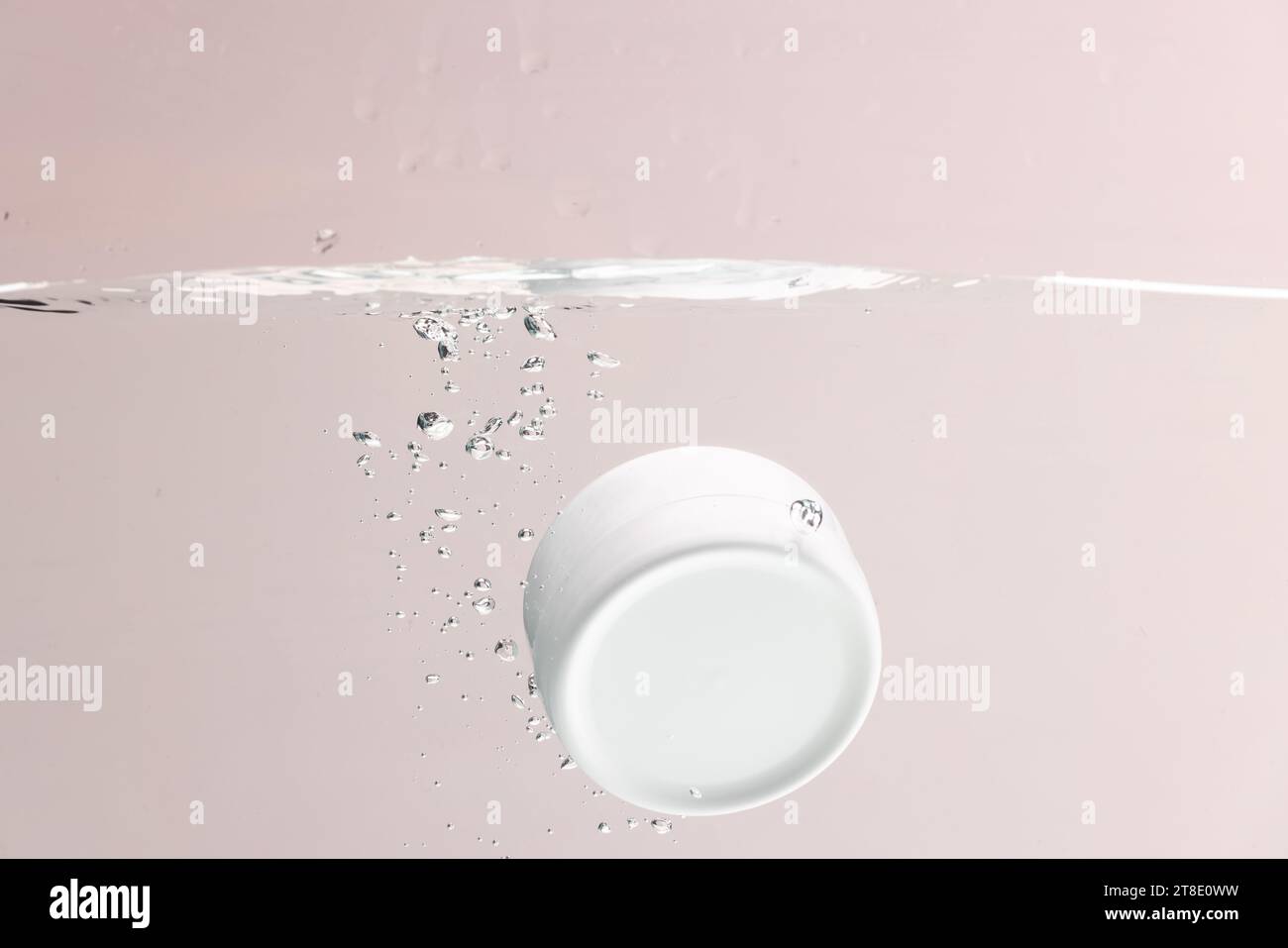 Vasca da bagno che cade in acqua con spazio per le copie su sfondo rosa Foto Stock