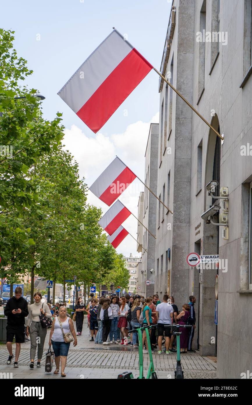 Persone in fila. Bandiere della Polonia per strada. National Polish Bank NBP, Narodowy Bank Polski. Money Center. Sede centrale di Centrum Pieniadza. Polonia, Varsavia - 27 luglio 2023. Foto Stock