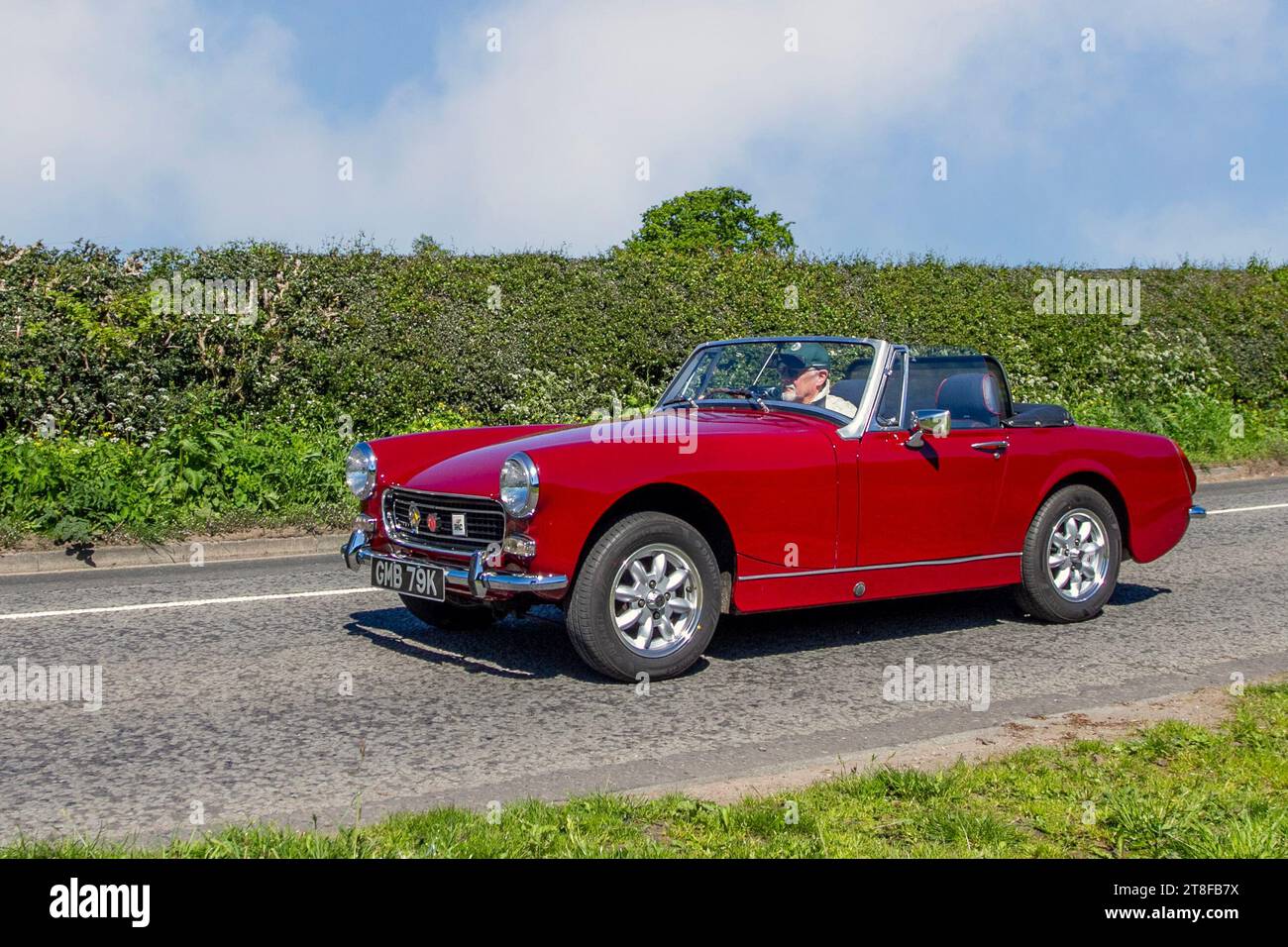 Anni '1972 70 Red MG Midget roadster a 2 porte; motori britannici restaurati, collezionisti di automobili, appassionati di motori e auto storiche d'epoca che viaggiano nel Cheshire, Regno Unito Foto Stock