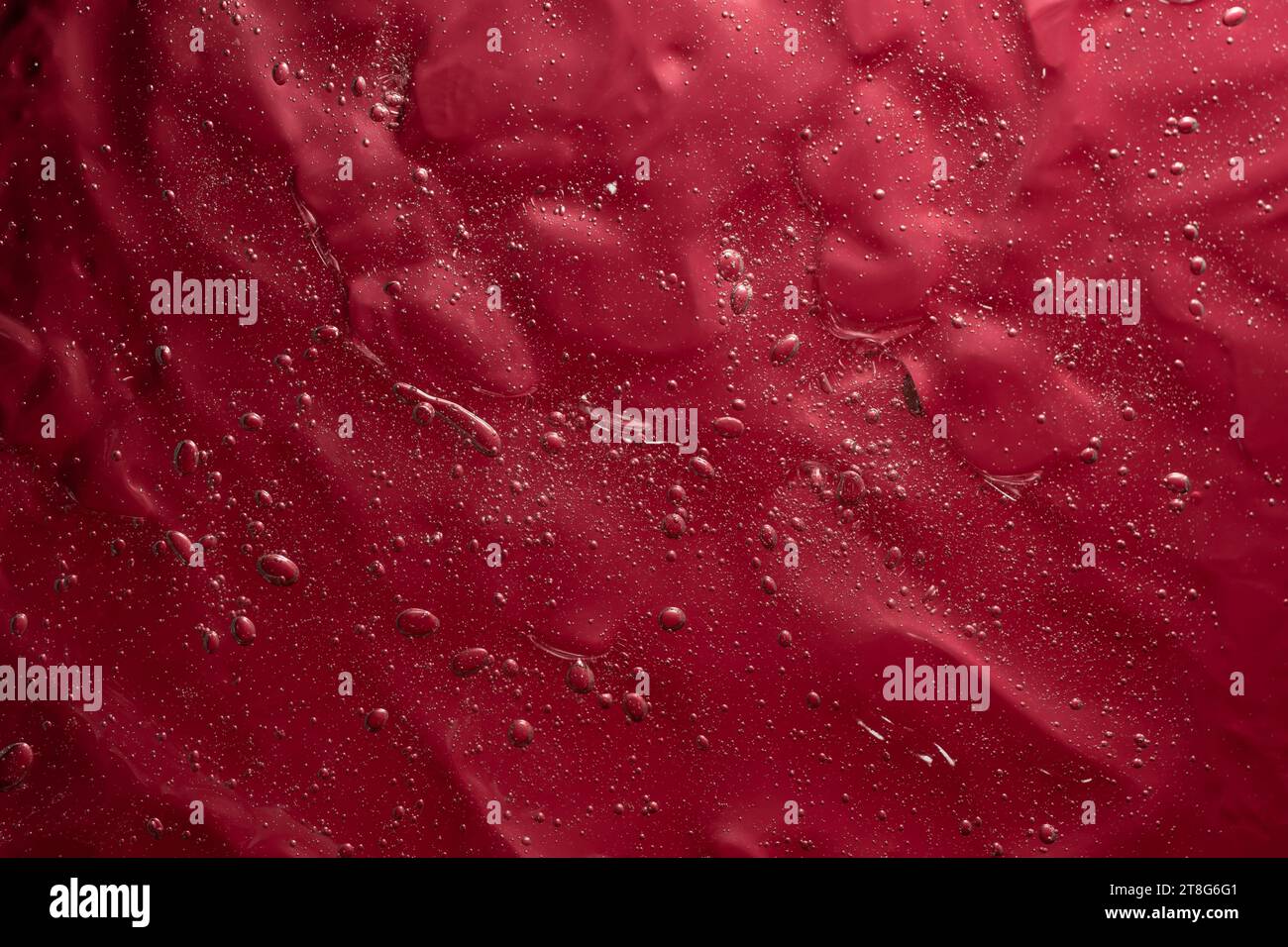 Struttura in gel astratta con bolle d'aria su sfondo rosso, sfondo astratto Foto Stock