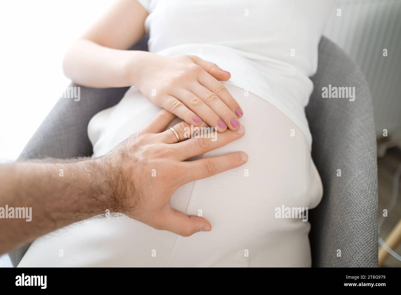 Uomini e donne mani sullo stomaco incinta. Aspettavo un bambino. Foto Stock