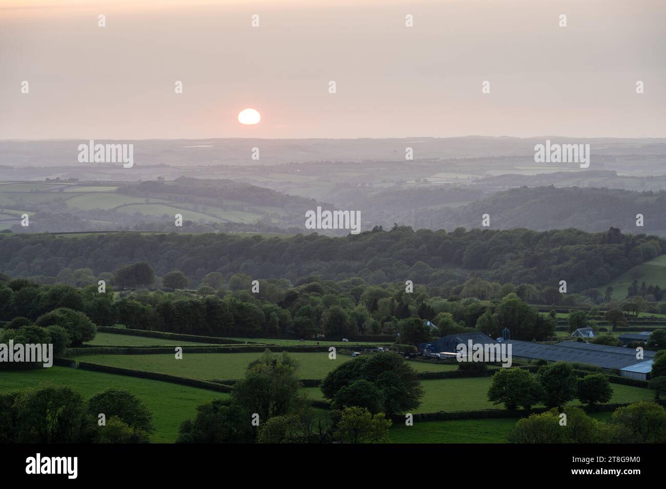 Il sole tramonta sulla Lyd Valley nel West Devon, visto dalla collina Brent Tor a Dartmoor. Foto Stock
