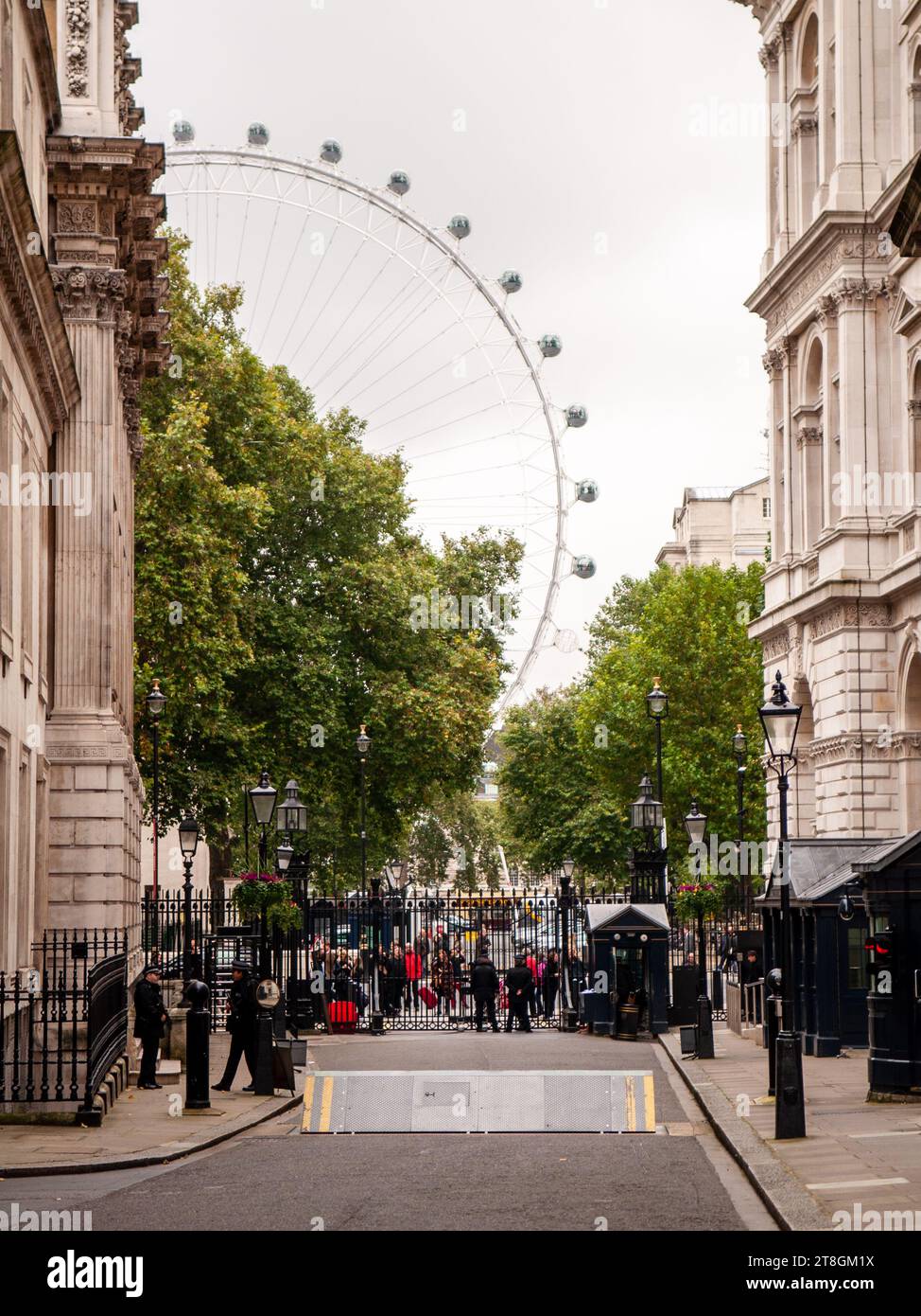 La polizia controlla i cancelli di Downing Street, tra il Gabinetto e gli edifici governativi del Foreign Office nella Whitehall di Londra, con il London Ey Foto Stock