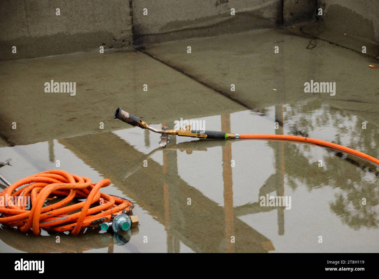 Il tubo flessibile e il bruciatore di una bombola di gas sono nell'acqua Foto Stock