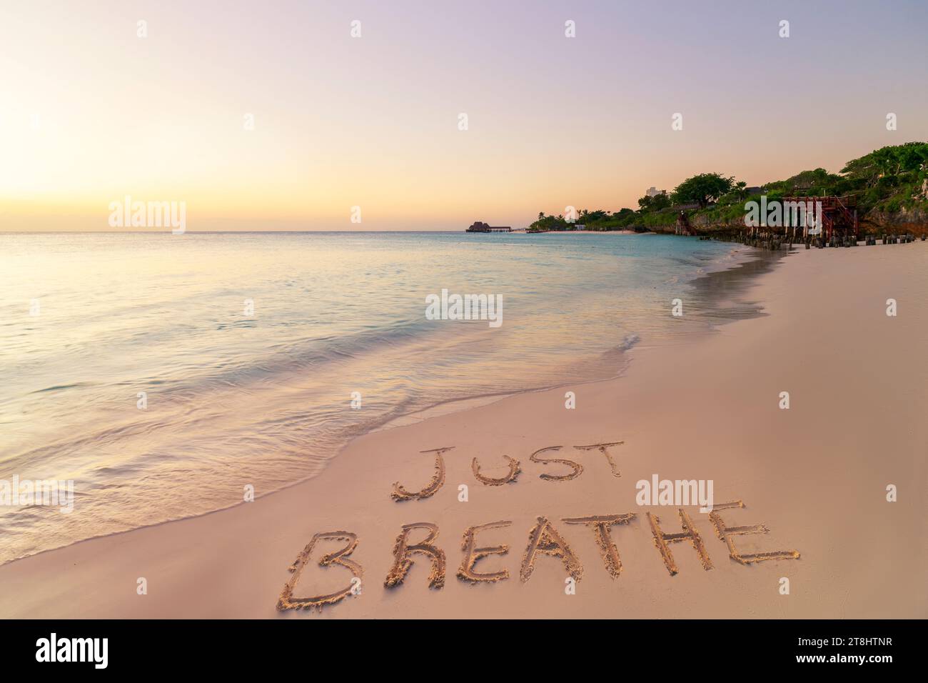Scritta a mano, respira sulla spiaggia di sabbia al tramonto, relax e concetto estivo, Zanzibar, spiaggia di Kendwa, Tanzania. Foto Stock
