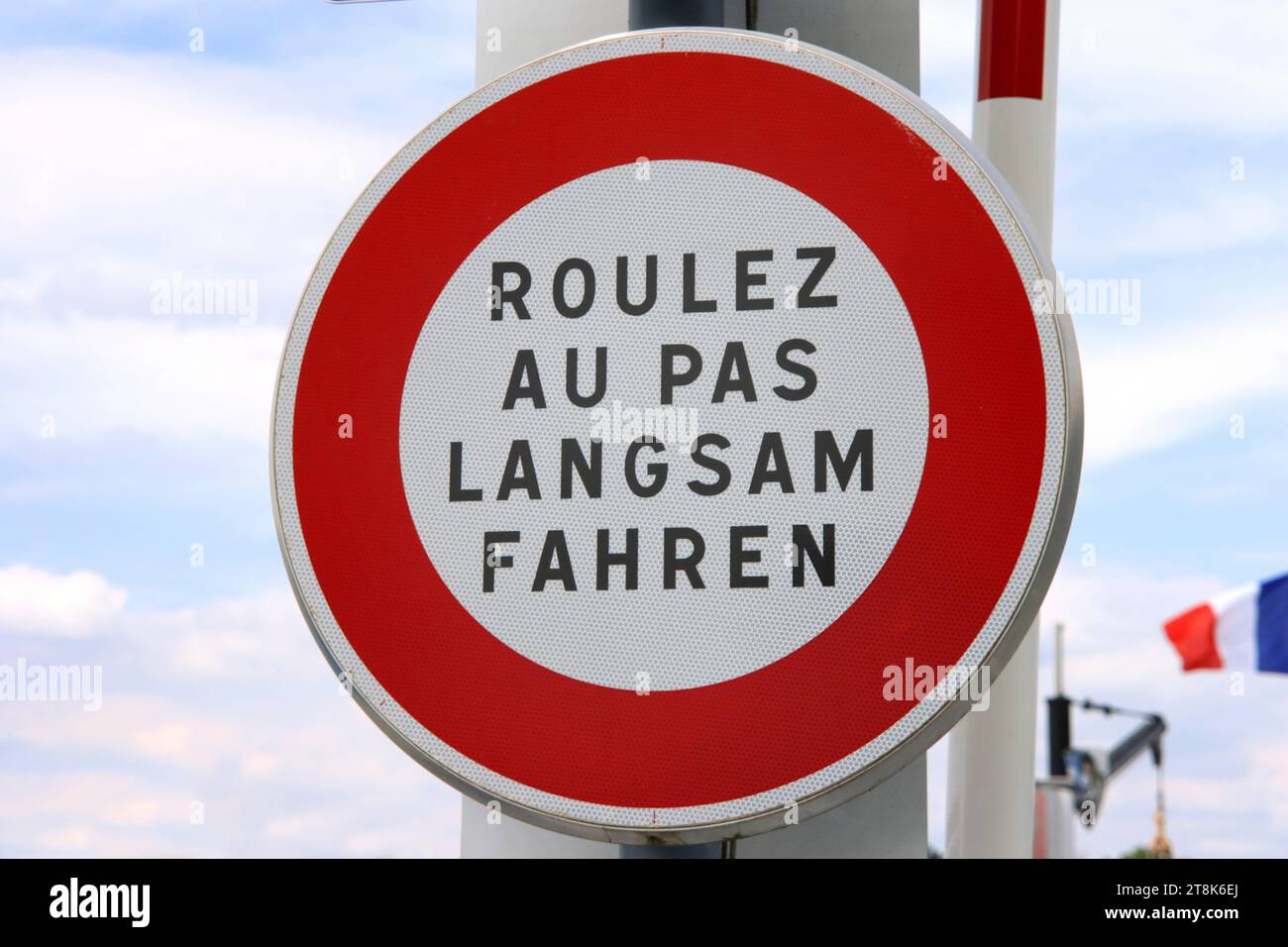 Cartello stradale con la scritta Roulez au pas, Langsam fahren, guida lentamente, Francia Foto Stock
