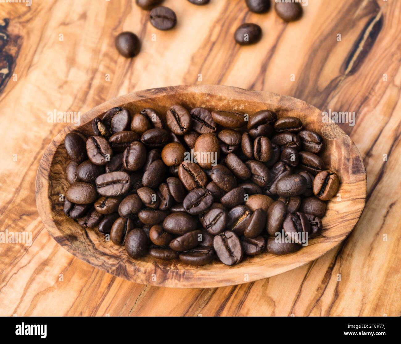 I chicchi di caffè in una ciotola di legno Foto Stock