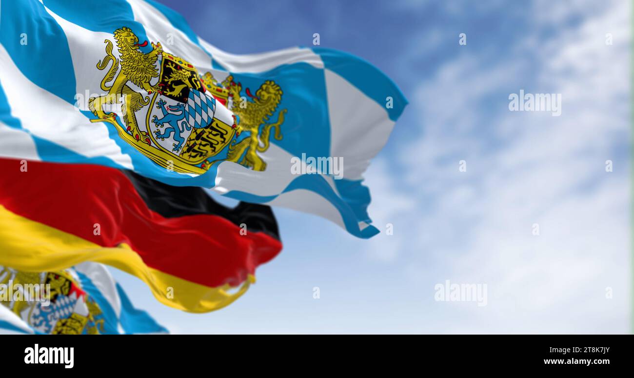 Bandiere bavaresi che sventolano con bandiera nazionale tedesca in una giornata limpida. La Baviera è uno stato nel sud-est della Germania. rendering dell'illustrazione 3d. Selettivo FOC Foto Stock
