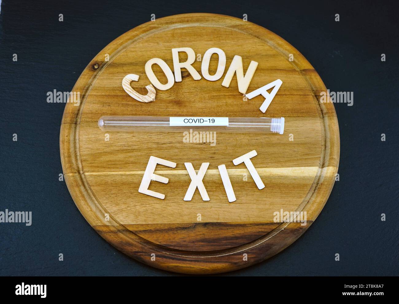 Tavola di legno con scritta Corona e uscita, tubulo di prova Foto Stock