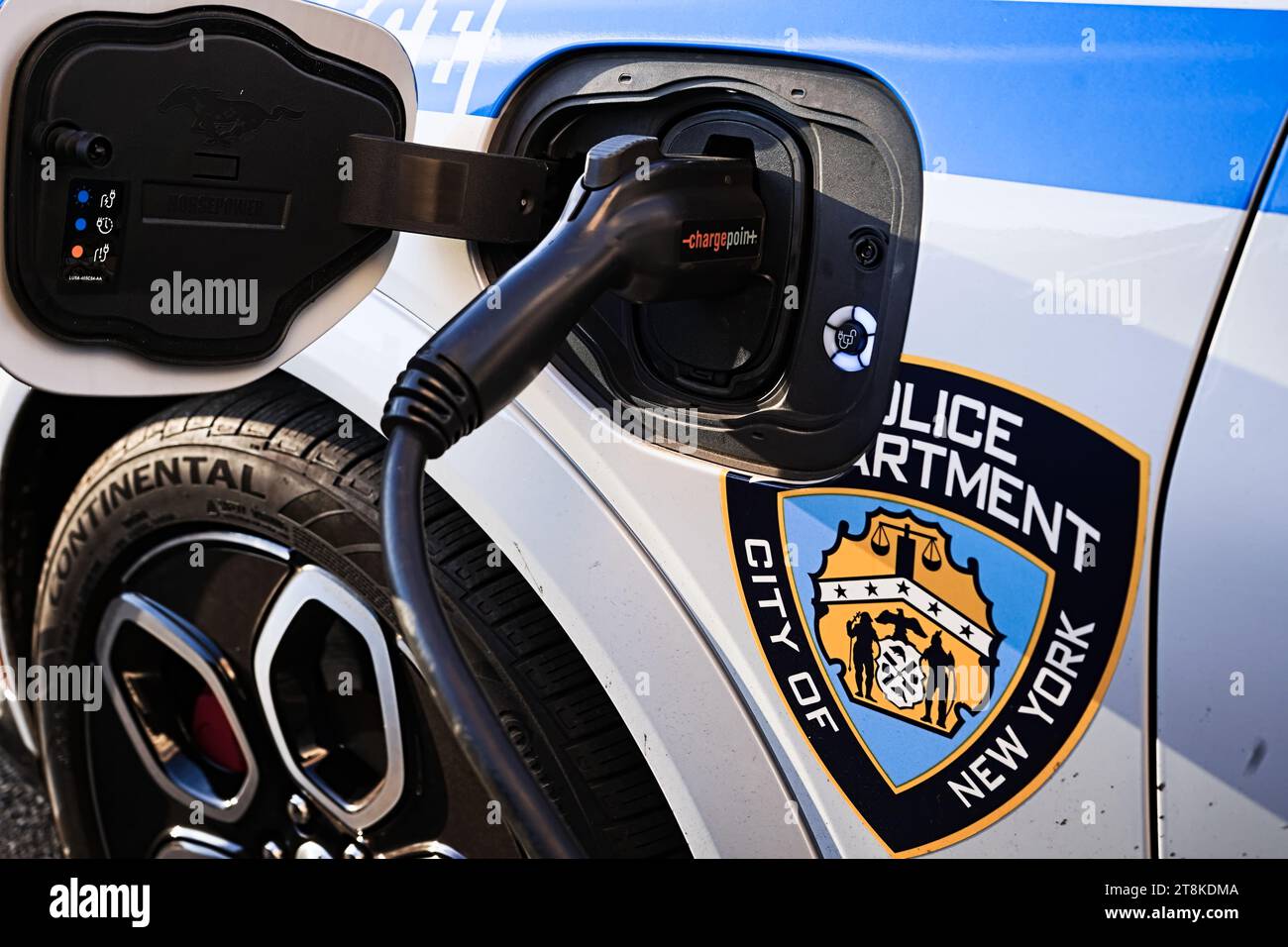 New York, New York - 20 novembre 2023: Servizio di polizia City of New York ricarica di auto di pattuglia EV con presa per veicolo elettrico ChargePoint sulla strada all'esterno Foto Stock