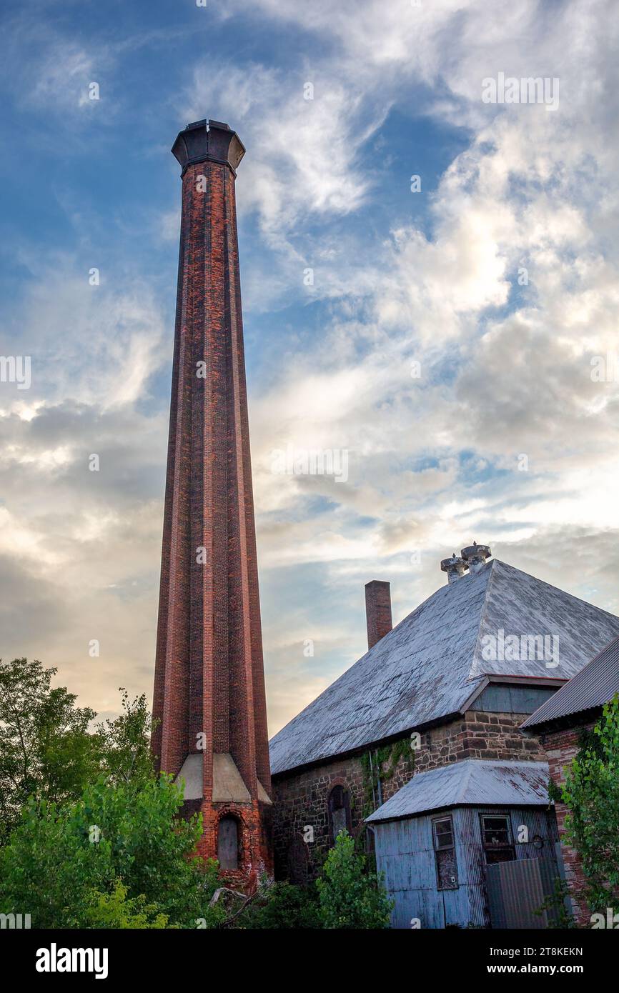 Edificio in mattoni con fusto e pietra adagiato su un cielo spettacolare. I concetti potrebbero includere l'industria vintage, l'architettura, l'artigianato, lo sviluppo urbano Foto Stock