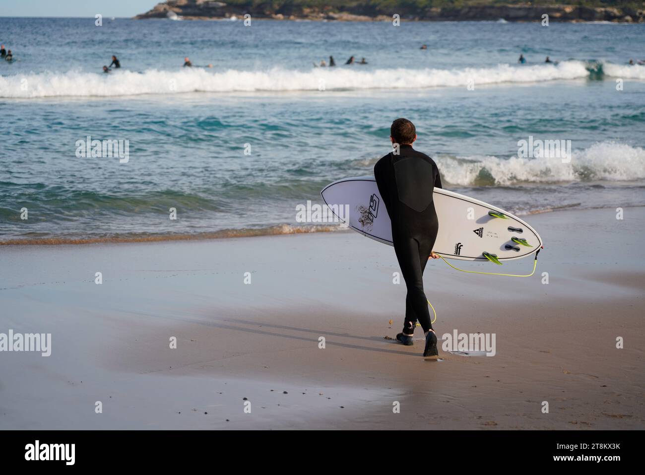 Un surfista si prepara ad entrare in acqua a Maroubra Beach. Foto Stock