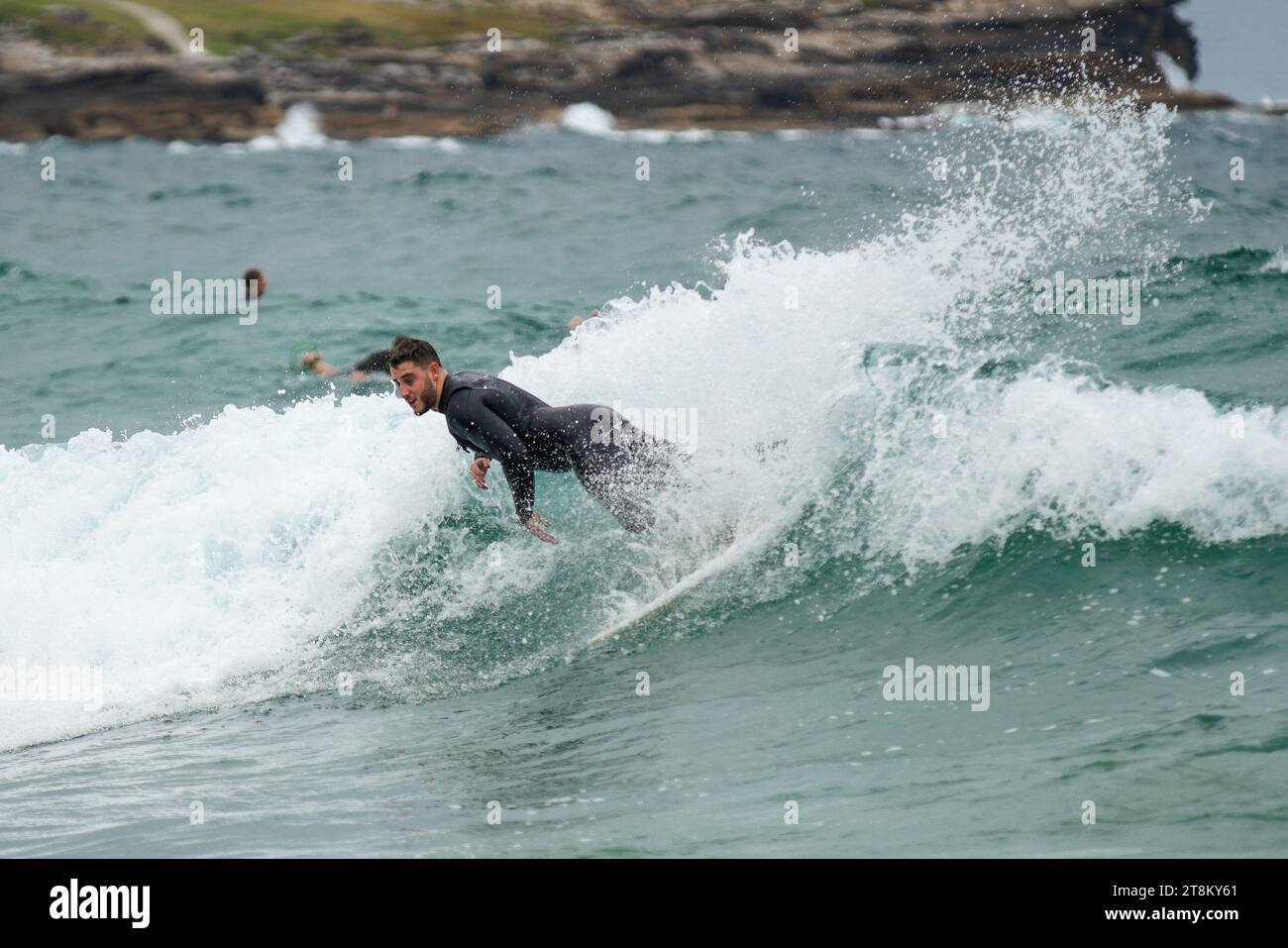 Un surfista cavalca un'onda modesta a Maroubra Beach. Foto Stock