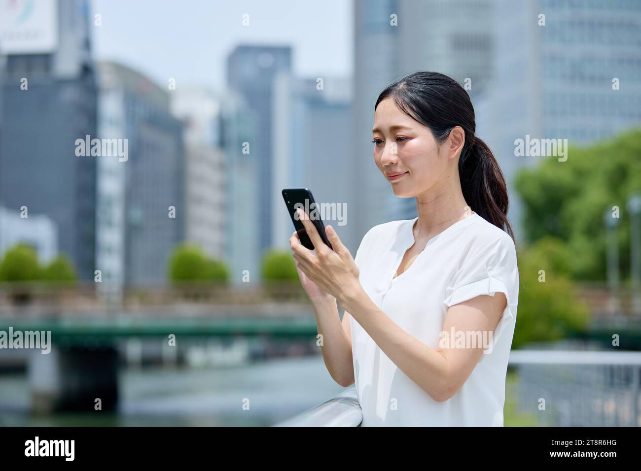 Donna giapponese che usa uno smartphone nel centro di Tokyo Foto Stock