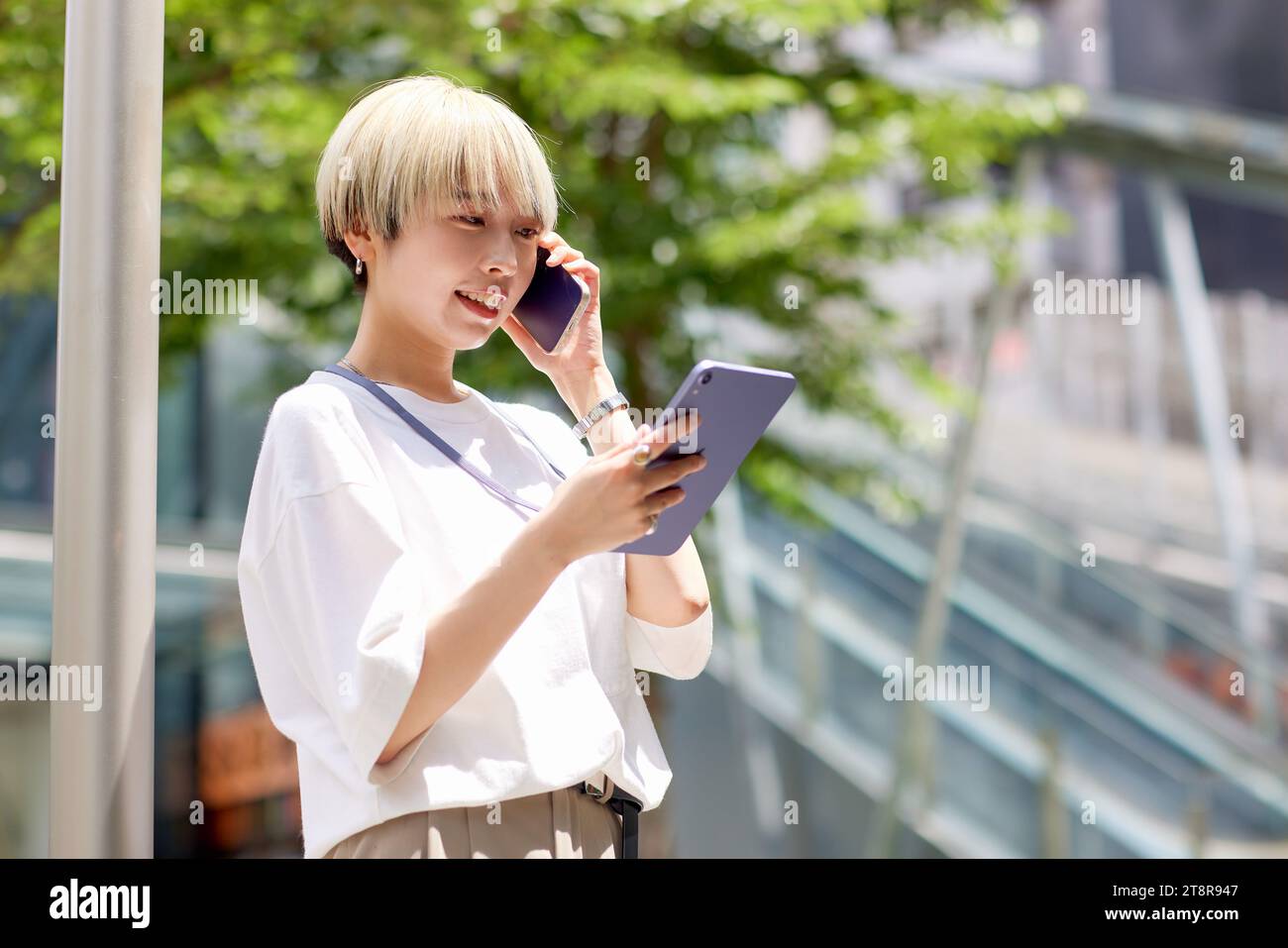 Giovane donna giapponese che parla al telefono nel centro di Tokyo Foto Stock