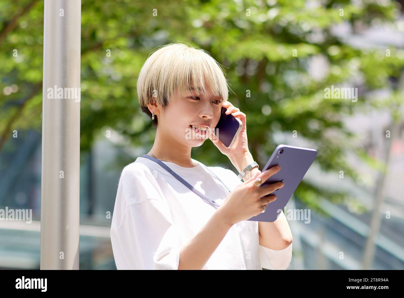 Giovane donna giapponese che parla al telefono nel centro di Tokyo Foto Stock