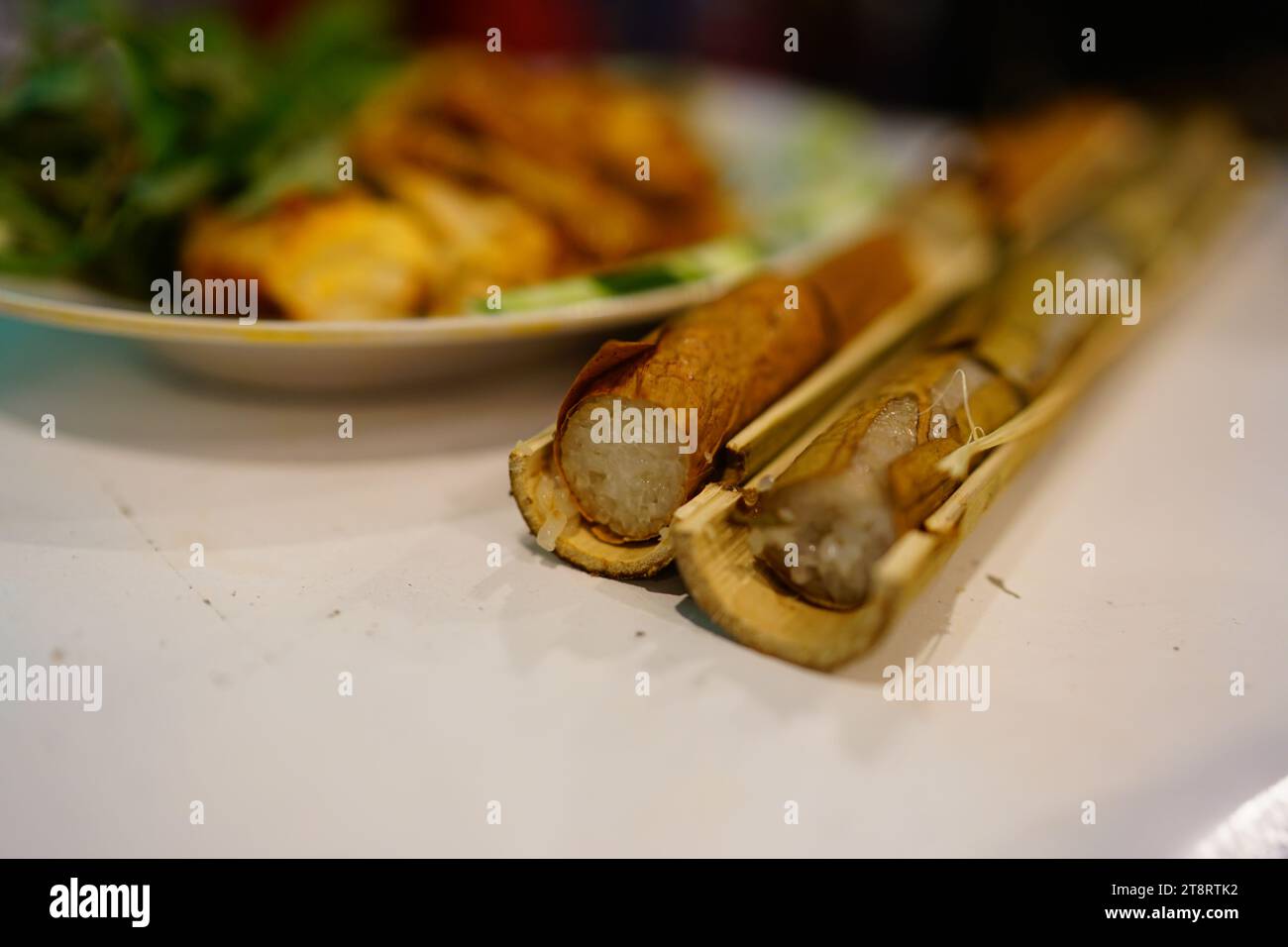 Riso cotto al tubino di bambù e pollo alla griglia Foto Stock