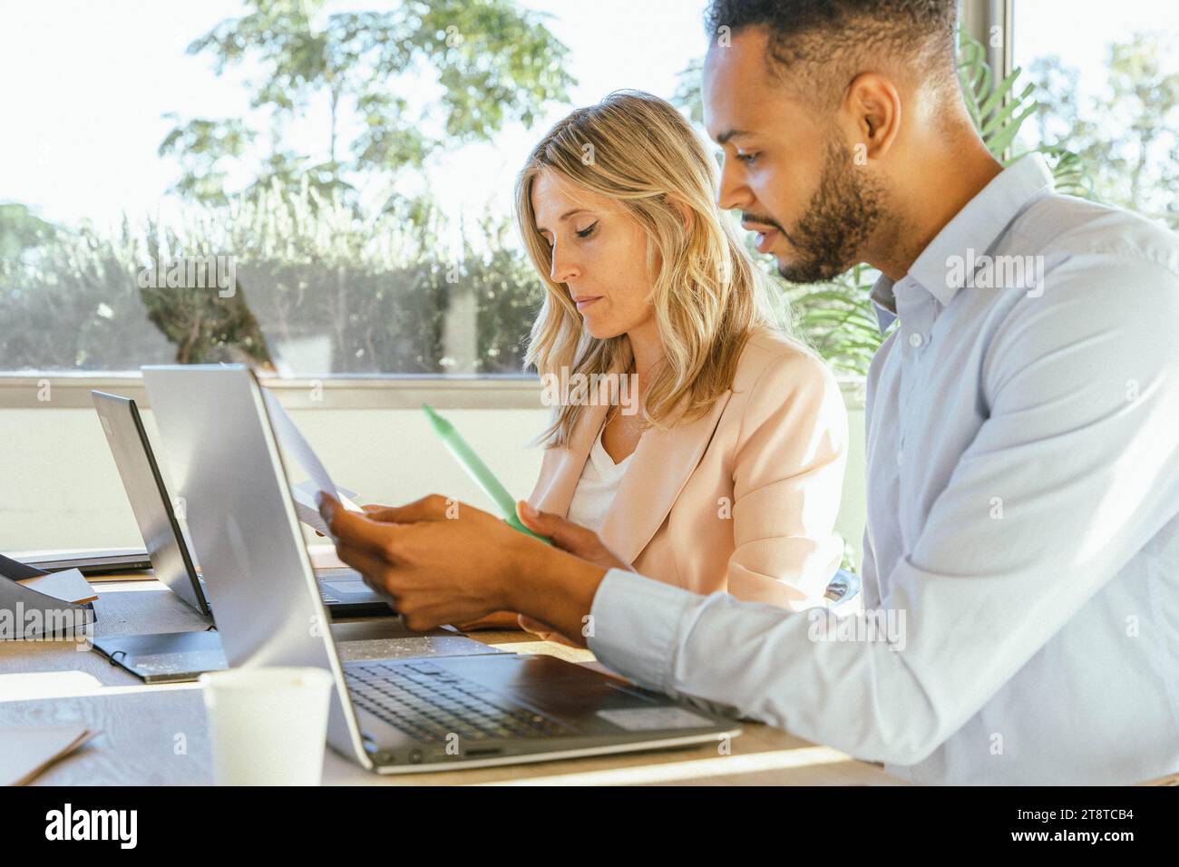 Colleghi che analizzano i dati e condividono le idee mentre lavorano insieme in ufficio. Concetto aziendale. Foto Stock