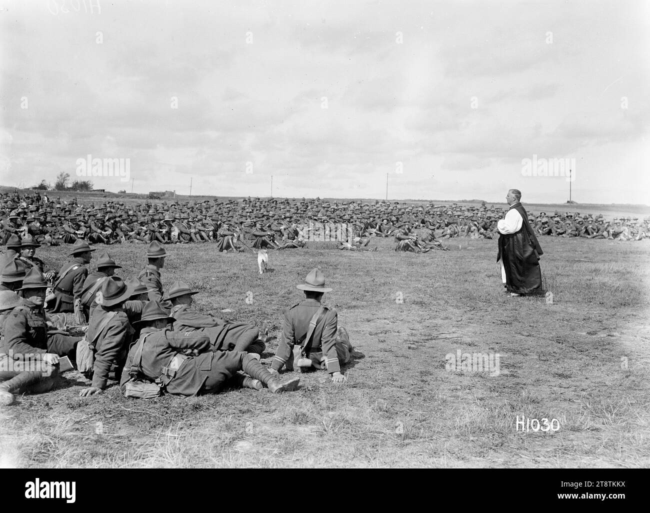 Un servizio ecclesiastico della New Zealand Brigade in Francia, prima guerra mondiale, Un prete che parla ai soldati seduti a terra in un servizio ecclesiastico della New Zealand Brigade alla presenza del Comandante di corpo e generale di divisione (in mezzo al terreno). Un piccolo cane (mascotte?) è visibile anche sull'erba. Foto scattata a Sapignies, Francia, 8 settembre 1918 Foto Stock