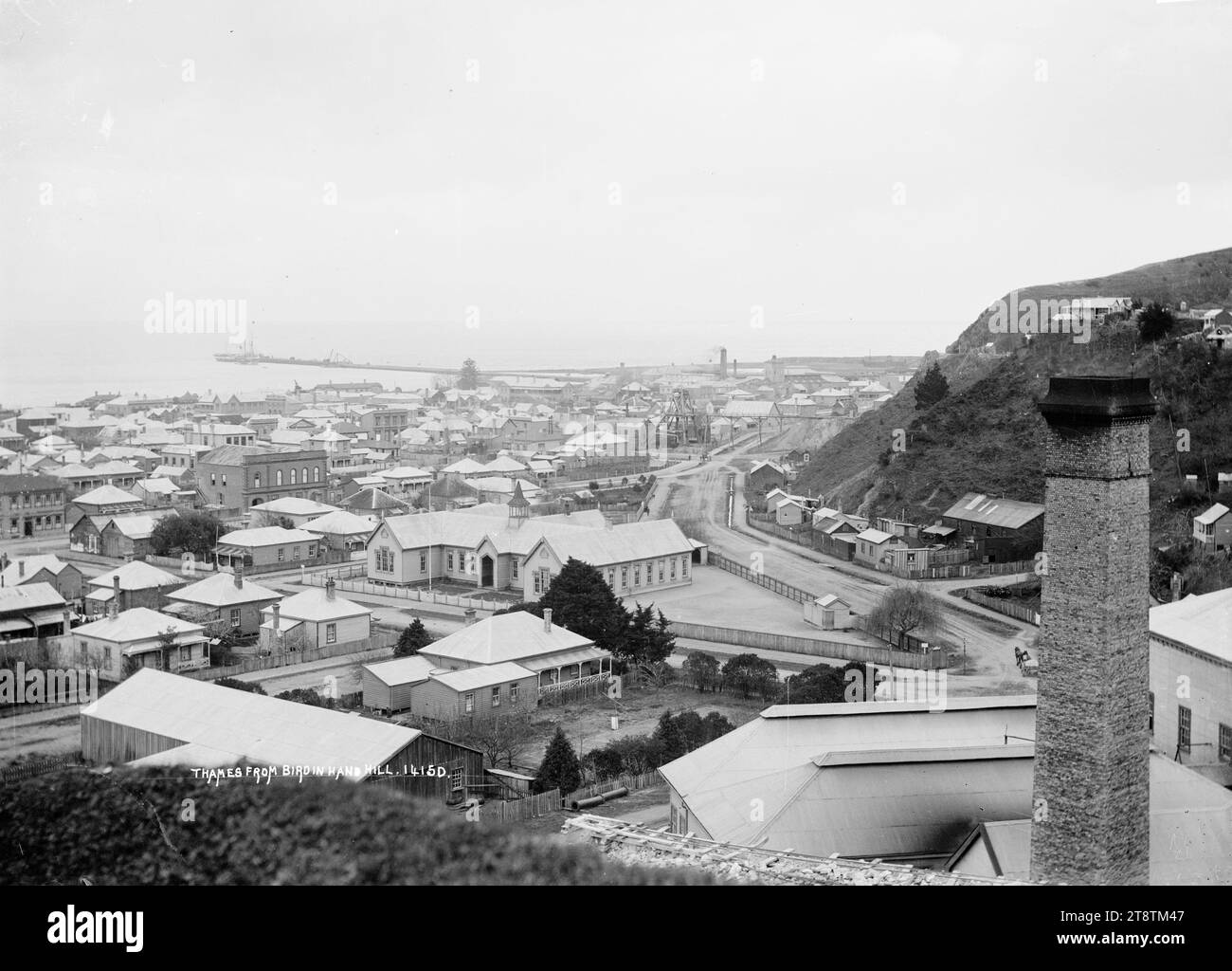 Affacciato sul Tamigi, affacciato sul Tamigi da Bird-in-Hand Hill, risalente al 1900 circa. A media distanza si trova la Thames Central School, e di fronte alla scuola, la residenza di Farley Smith (con alberi che crescono sul fronte della strada). Il camino della miniera Queen of Beauty si trova nell'immediato primo piano a destra. Il Burke Street Wharf (Thames Wharf, Goods Wharf) e Moanataiari possono essere visti in lontananza Foto Stock