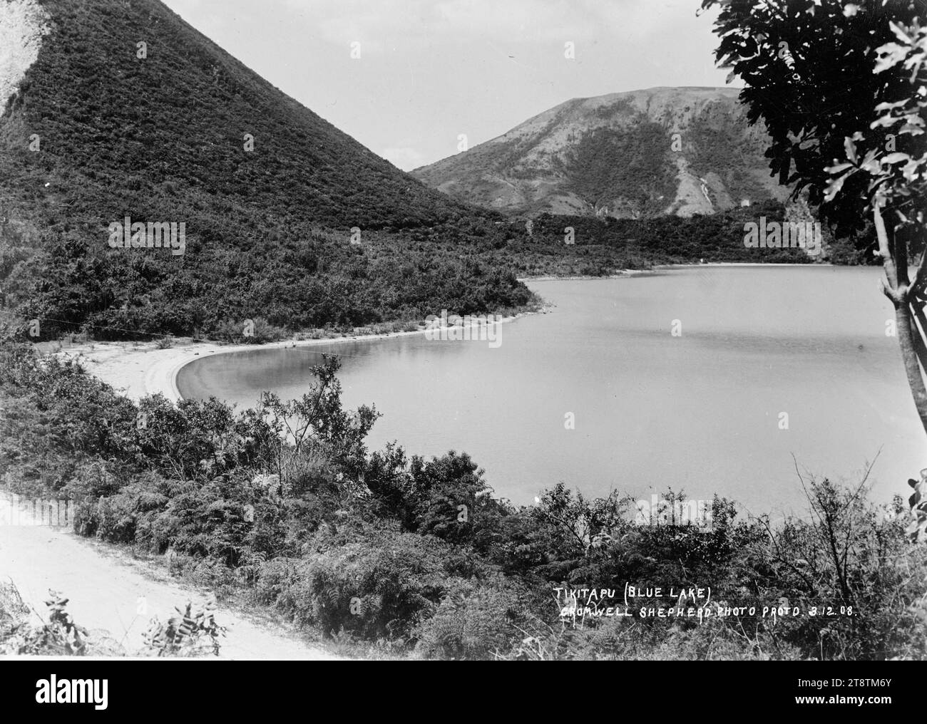 Blue Lake, Rotorua - Fotografia scattata da Cromwell Shepherd, Vista del Lago Tikitapu, conosciuto come il Lago Blu, e della costa sabbiosa. In primo piano c'è una strada. Copia di una fotografia scattata da Cromwell Shepherd il 3 dicembre 1908 Foto Stock