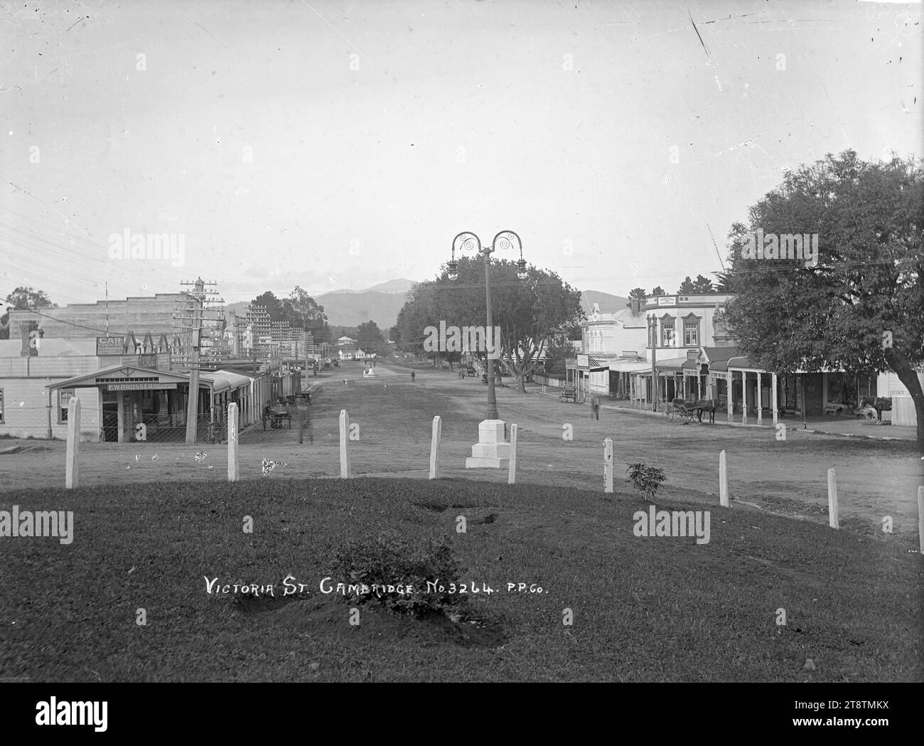 Victoria Street, Cambridge, Vista di Victoria Street, Cambridge. Un lampione in ferro battuto si trova al centro dell'immagine, con edifici commerciali su entrambi i lati della strada. La sede di F W Prosser, agenti immobiliari, è in primo piano. circa 1910-1930 Foto Stock