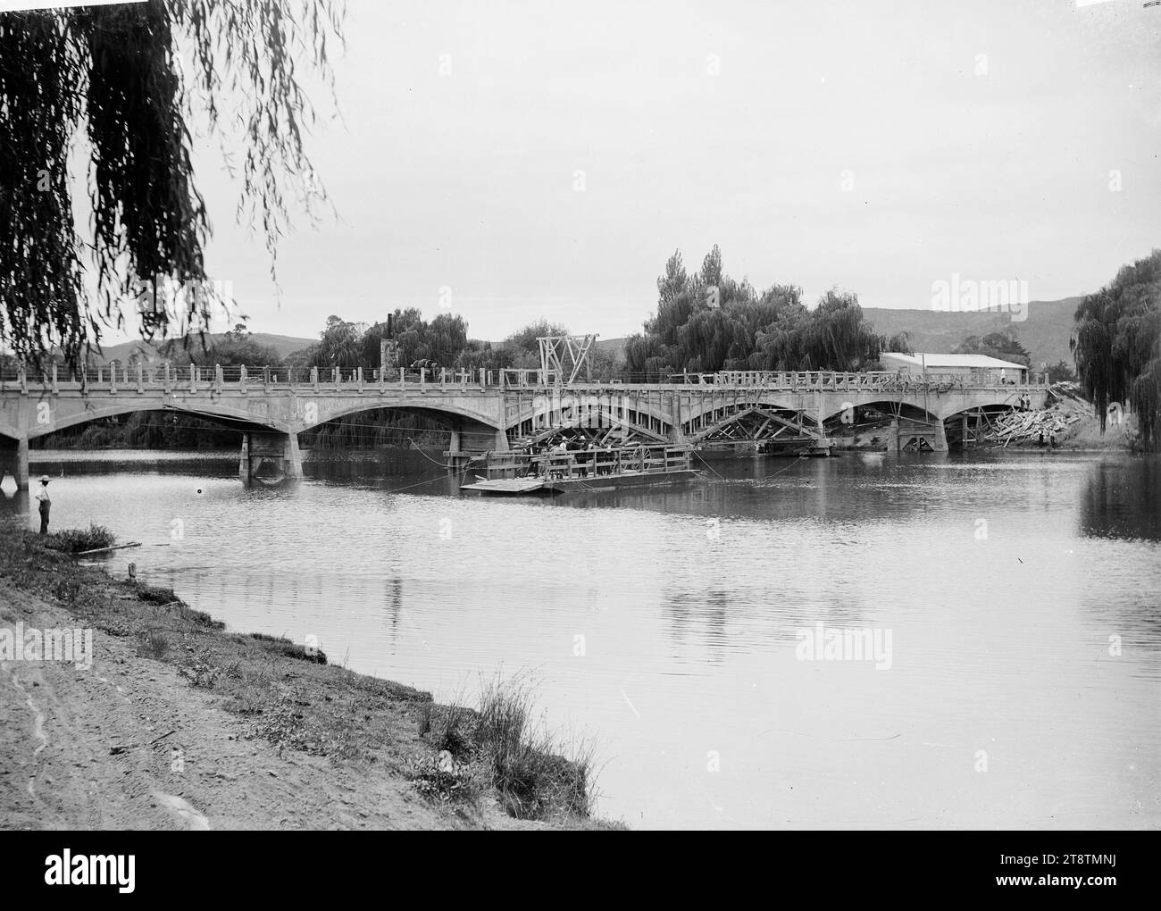 Fiume Whakatane, con ponte in costruzione, fiume Whakatane con ponte in costruzione. Un gruppo di uomini sta lavorando sotto una chiatta. Fotografato intorno agli anni '1910 Foto Stock