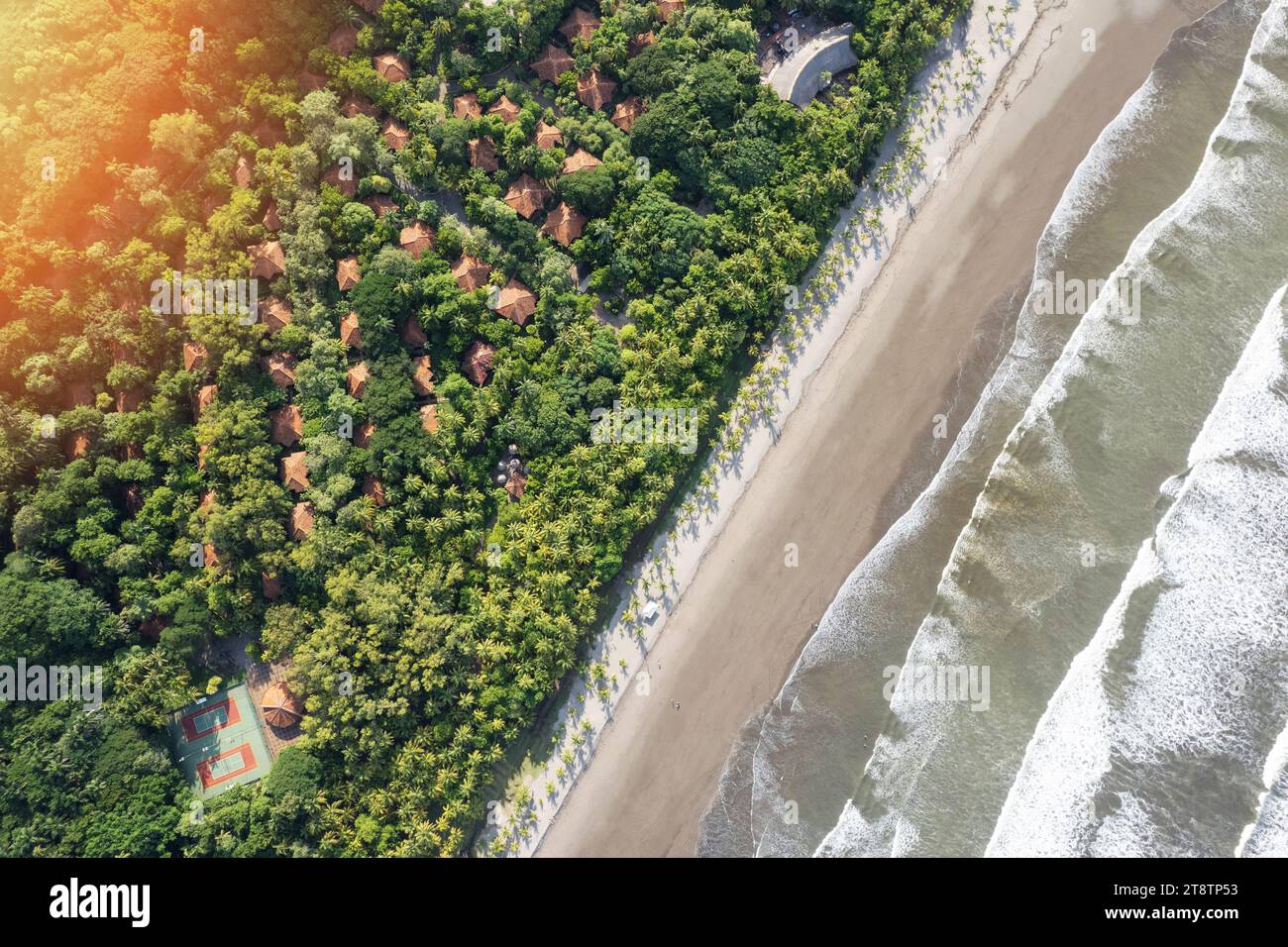 Luce del sole sul resort tropicale con vista sulla spiaggia e sul mare sopra la cima dei droni Foto Stock