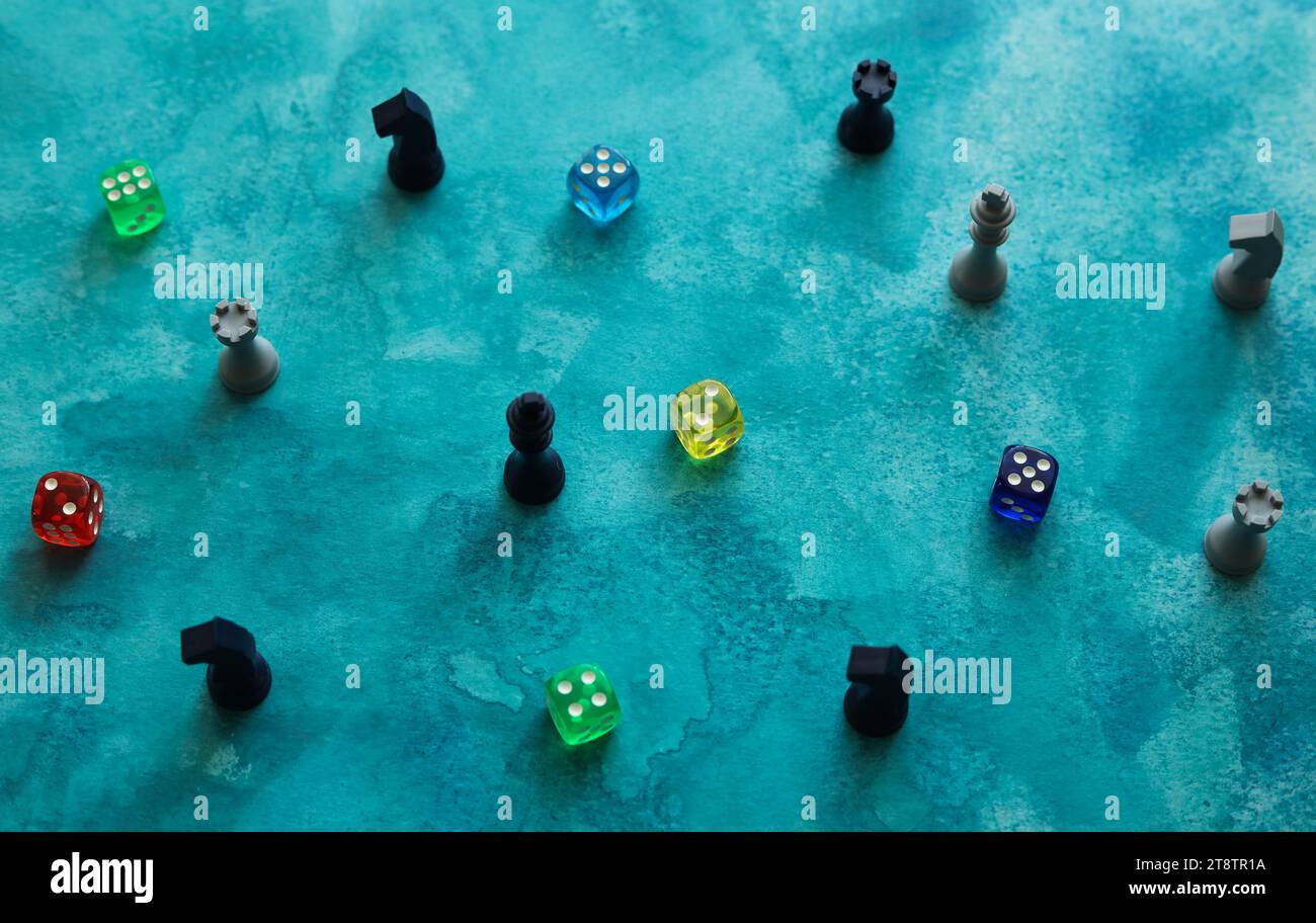 pezzi da scacchi e dadi colorati su uno sfondo blu acquerello Foto Stock