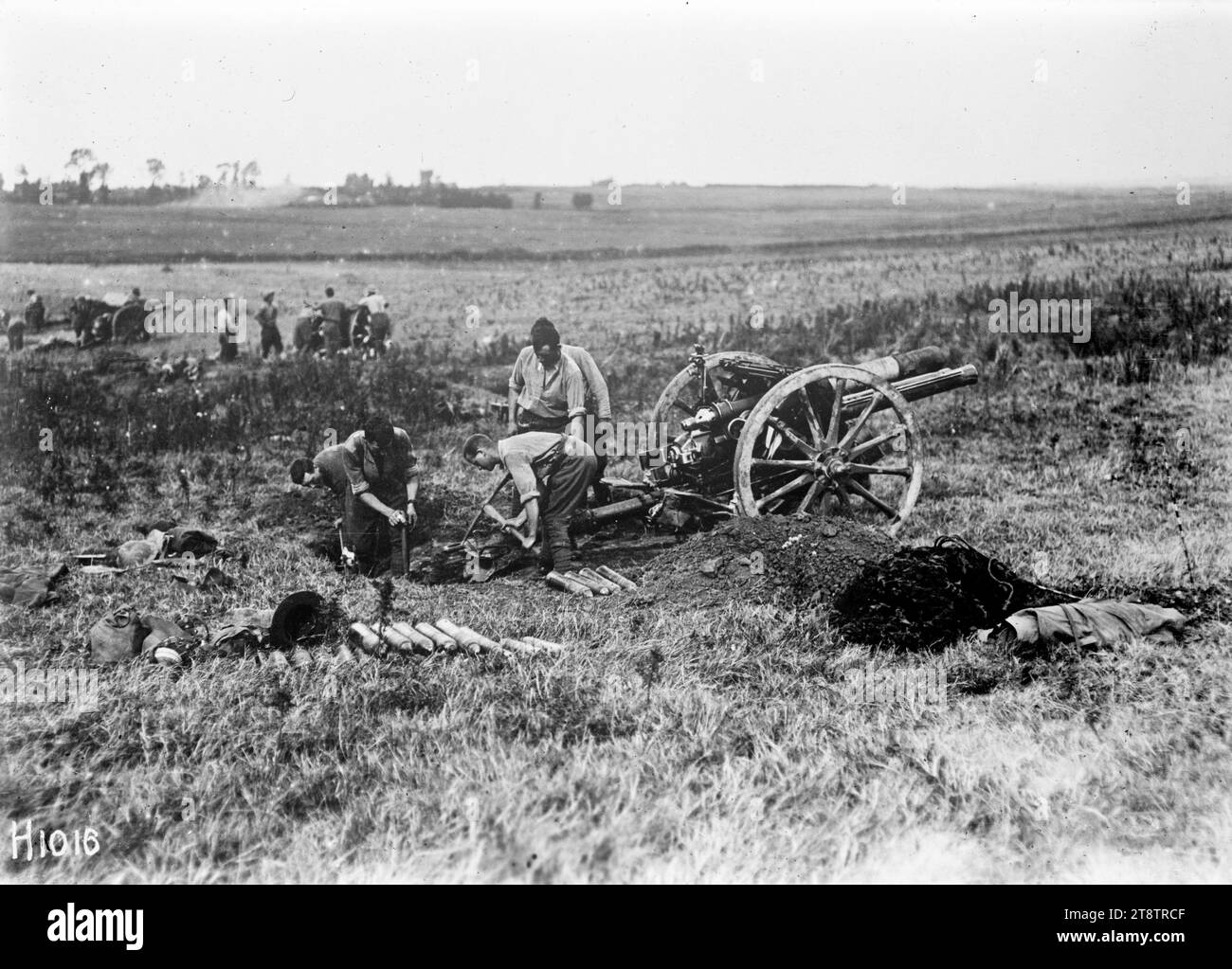 I neozelandesi preparano un cannone per l'azione in Francia durante la prima guerra mondiale, i soldati d'artiglieria neozelandesi, nelle loro maniche di camicia, preparano un cannone da campo per l'azione nella campagna francese (luogo specifico non identificato) durante la prima guerra mondiale Mostra che la pistola è fissata in posizione. Notare le pile di gusci intorno ad esso. Altre pistole sono visibili sullo sfondo. Fotografia scattata l'8 agosto 1918 Foto Stock