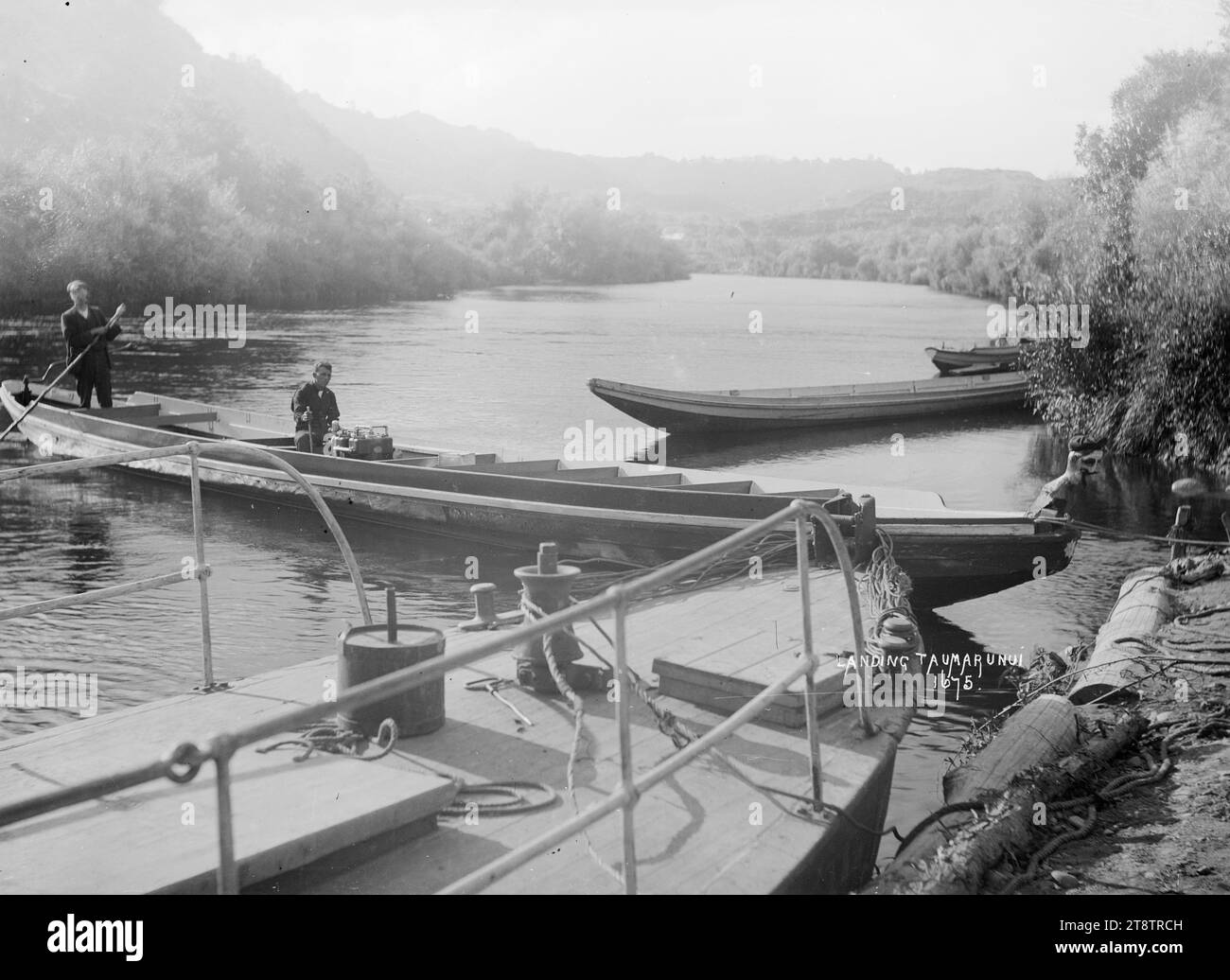 Uno sbarco sul fiume Whanganui a Taumarunui, veduta di uno sbarco sul fiume Whanganui a Taumarunui, con due canoe motorizzate lungo il molo tra il 1900 e il 1930 Foto Stock