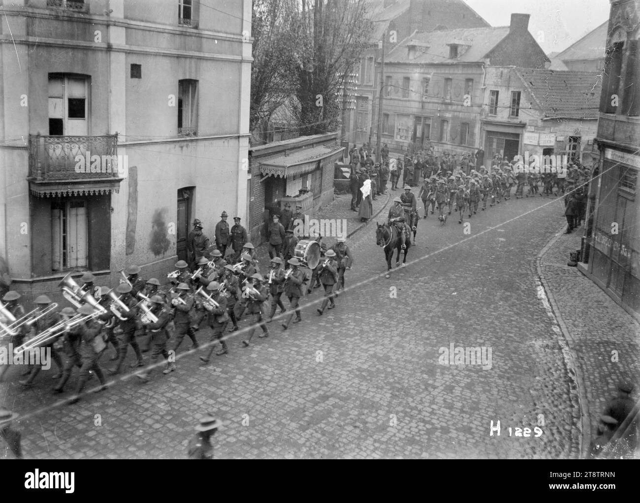 Divisione nuova Zelanda lasciando Solesmes, Francia, dopo l'armistizio che pose fine alla prima guerra mondiale, la Divisione nuova Zelanda lasciò la città di Solesmes, Francia, dopo l'armistizio che pose fine alla prima guerra mondiale Mostra una banda dell'esercito che guida una colonna di truppe in marcia attraverso una strada acciottolata. Fotografia scattata verso la fine di novembre 1918 Foto Stock