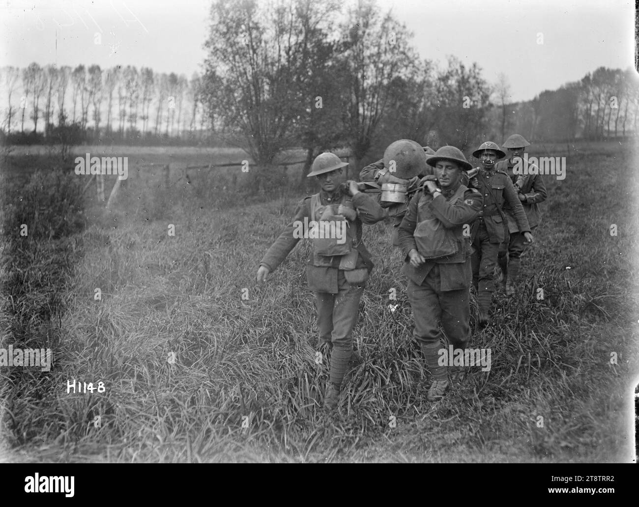 I portatori di barella neozelandesi che rimuovono i feriti a le Quesnoy, prima guerra mondiale, i portatori di barella neozelandesi spallano una barella che trasporta un soldato ferito dalla prima linea a le Quesnoy, Francia durante la prima guerra mondiale La festa cammina attraverso un campo erboso verso la telecamera. Fotografia scattata il 29 ottobre 1918 Foto Stock