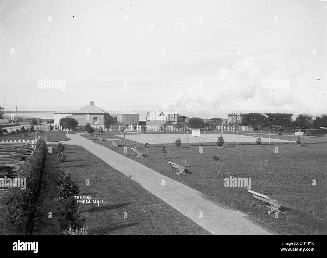 Victoria Park, Tamigi, vista del Victoria Park verso ovest. Mostra alberi recentemente piantati, panche da parco in ferro battuto, percorso in cemento e campi da tennis. A sinistra c'è un giardino di legname. Oltre i tribunali si trova una casa e un edificio esterno; anche un treno e carrozze. Il mare può essere visto in lontananza sulla sinistra. Foto scattata nei primi anni '1900 Foto Stock