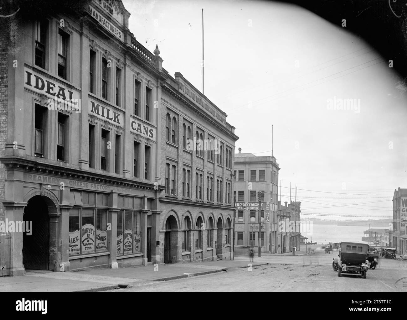 Alex Harvey & Sons, Albert Street, Auckland, nuova Zelanda, veduta dei locali commerciali di Alex Harvey & Sons Ltd al 5-7 di Albert Street. Accanto si trova la New Zealand Loan & Mercantile Agency Company Ltd Il Porto di Waitemata può essere visto alla fine della strada in lontananza. Preso nei primi anni '1900 Foto Stock