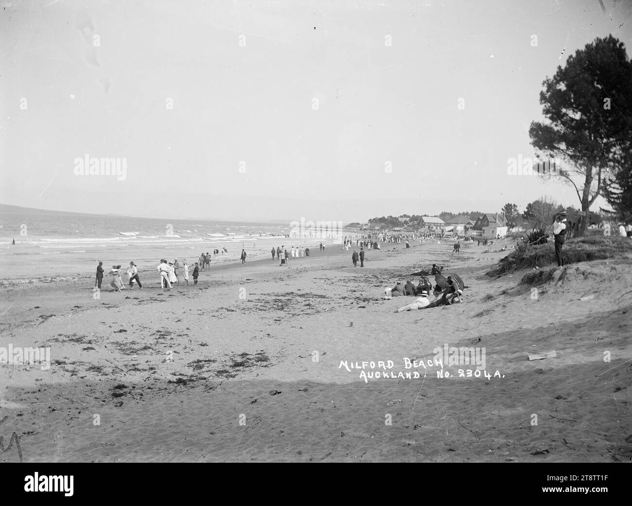 Milford Beach, Auckland, nuova Zelanda, vista a sud-est che mostra la gente a Milford Beach e nel mare. all'inizio degli anni '1900 Foto Stock