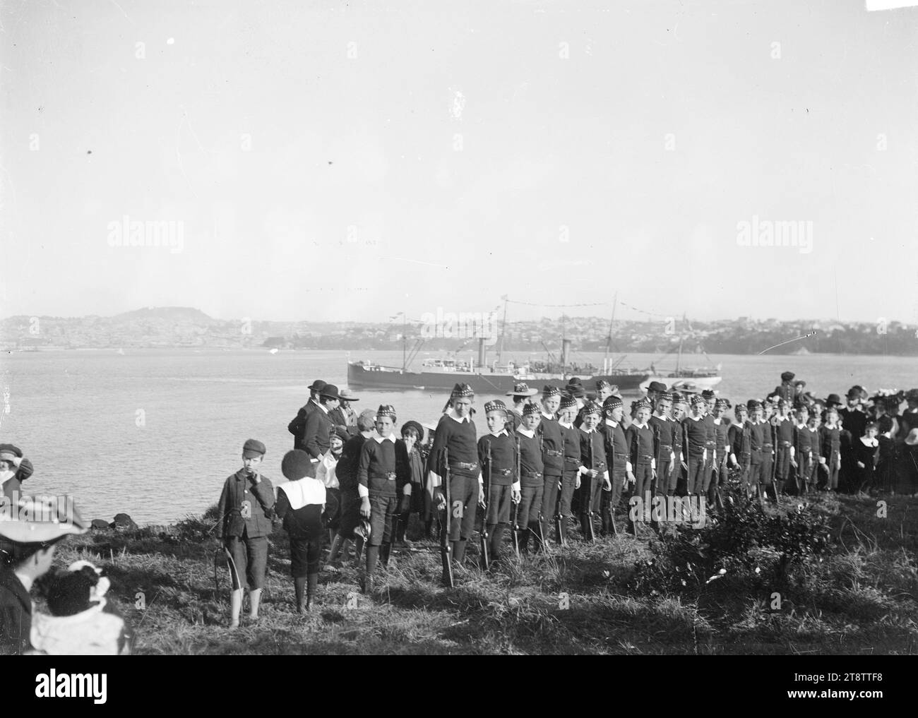 Cadetti scolastici a Northcote Point, Auckland, nuova Zelanda, cadetti scolastici in parata a Northcote Point, Auckland, nuova Zelanda, circa 1910. P di Auckland, nuova Zelanda. Due navi a vapore non identificate (con bunting) possono essere viste nel porto Foto Stock